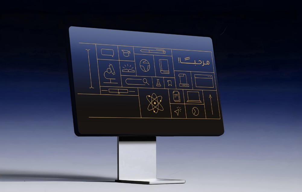 Minimalist computer monitor displaying a digital interface of golden education and science icons, including a microscope, atom, and globe, with Arabic text 'Marhaba' (Welcome) on a dark blue background.