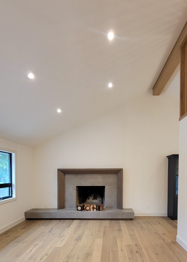 Image of KHD Homes interior design featuring a cozy fireplace in a spacious room with vaulted ceiling.
