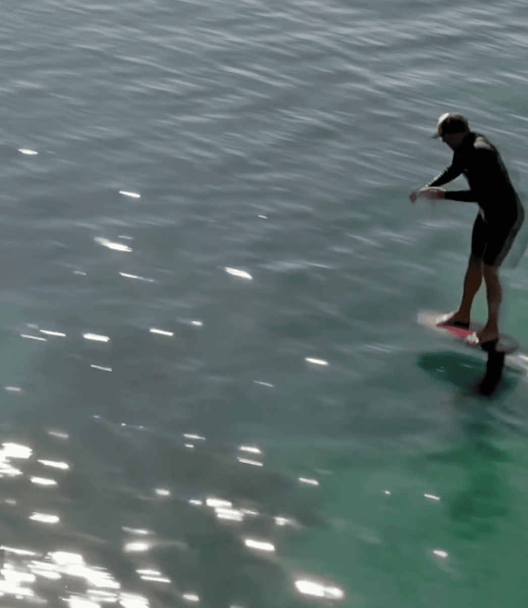 A man stading with Surfboard
