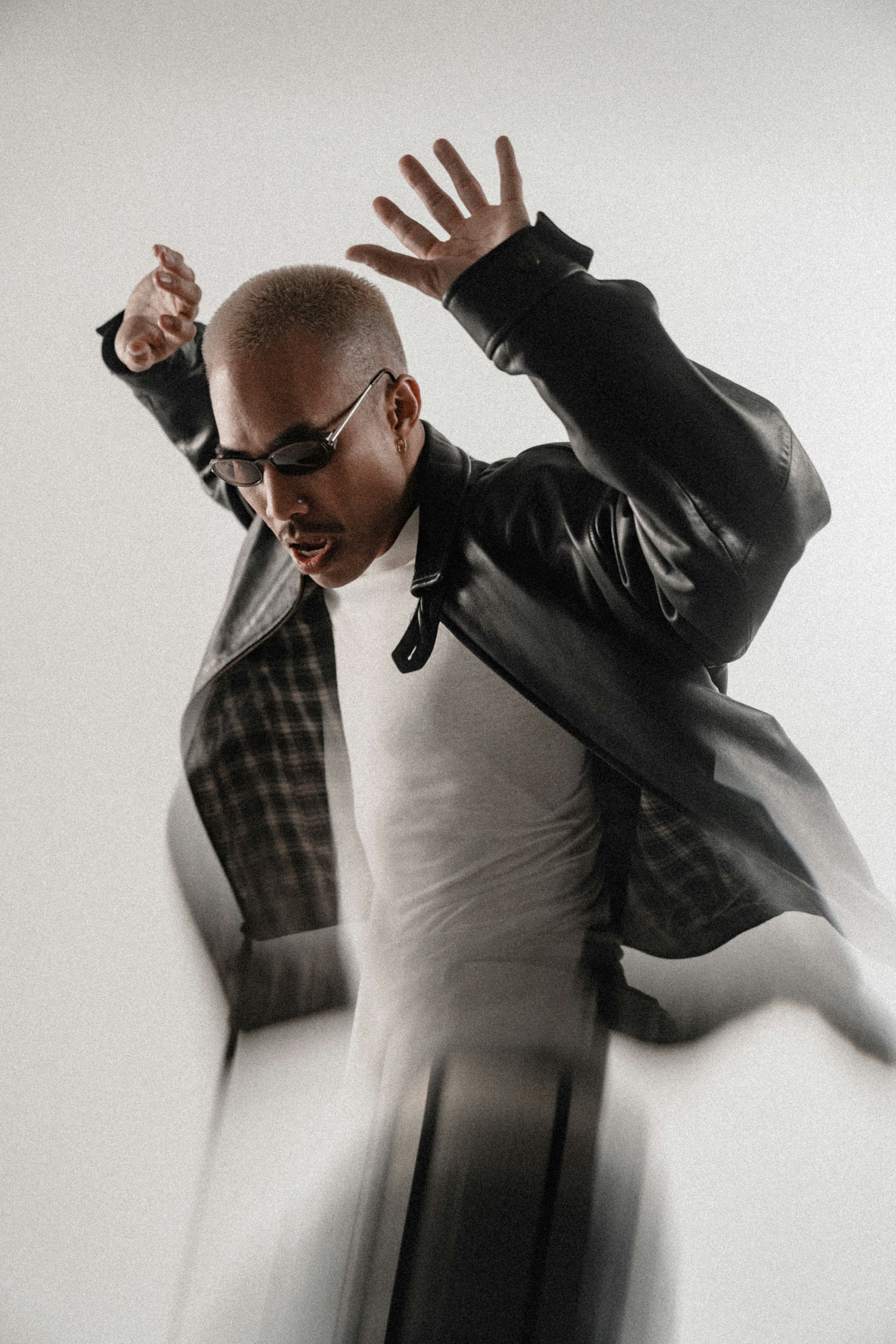 Man in black jacket dancing with arms raised