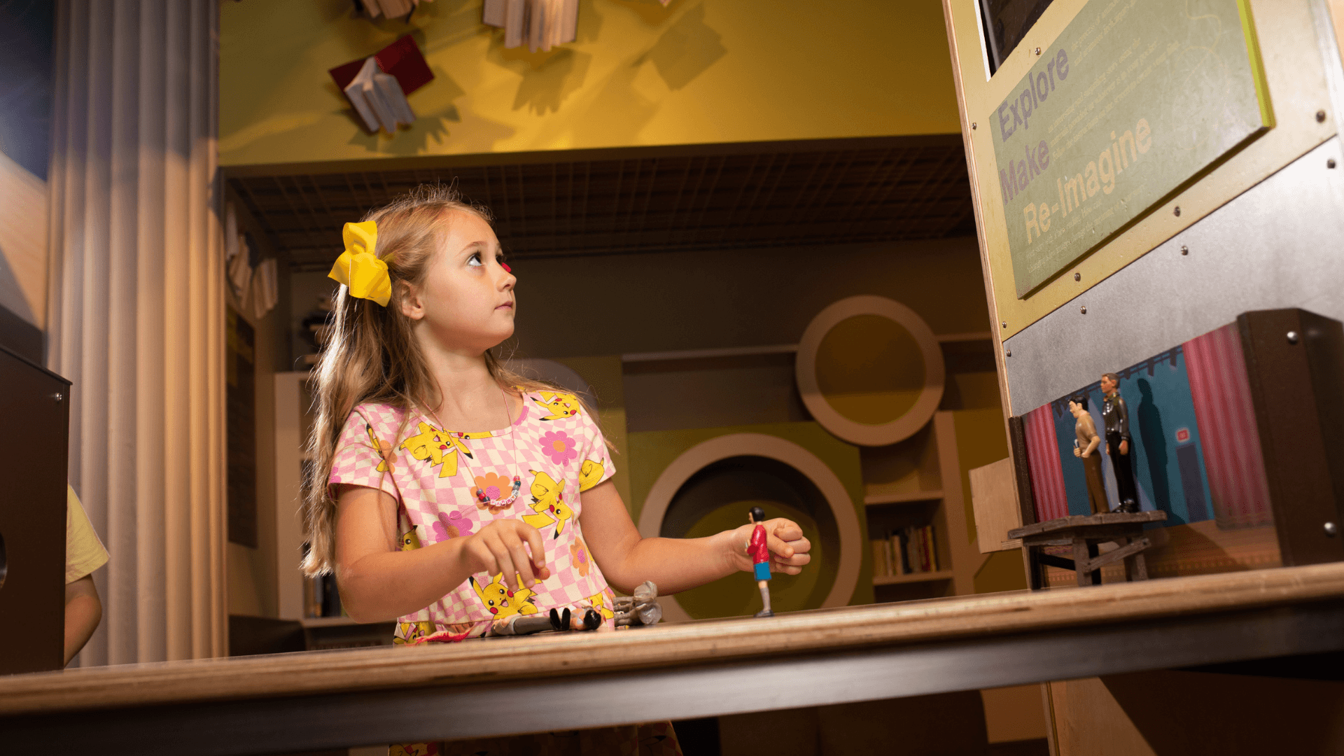 A young girl watches the screen as she puts together her stop-motion movie.
