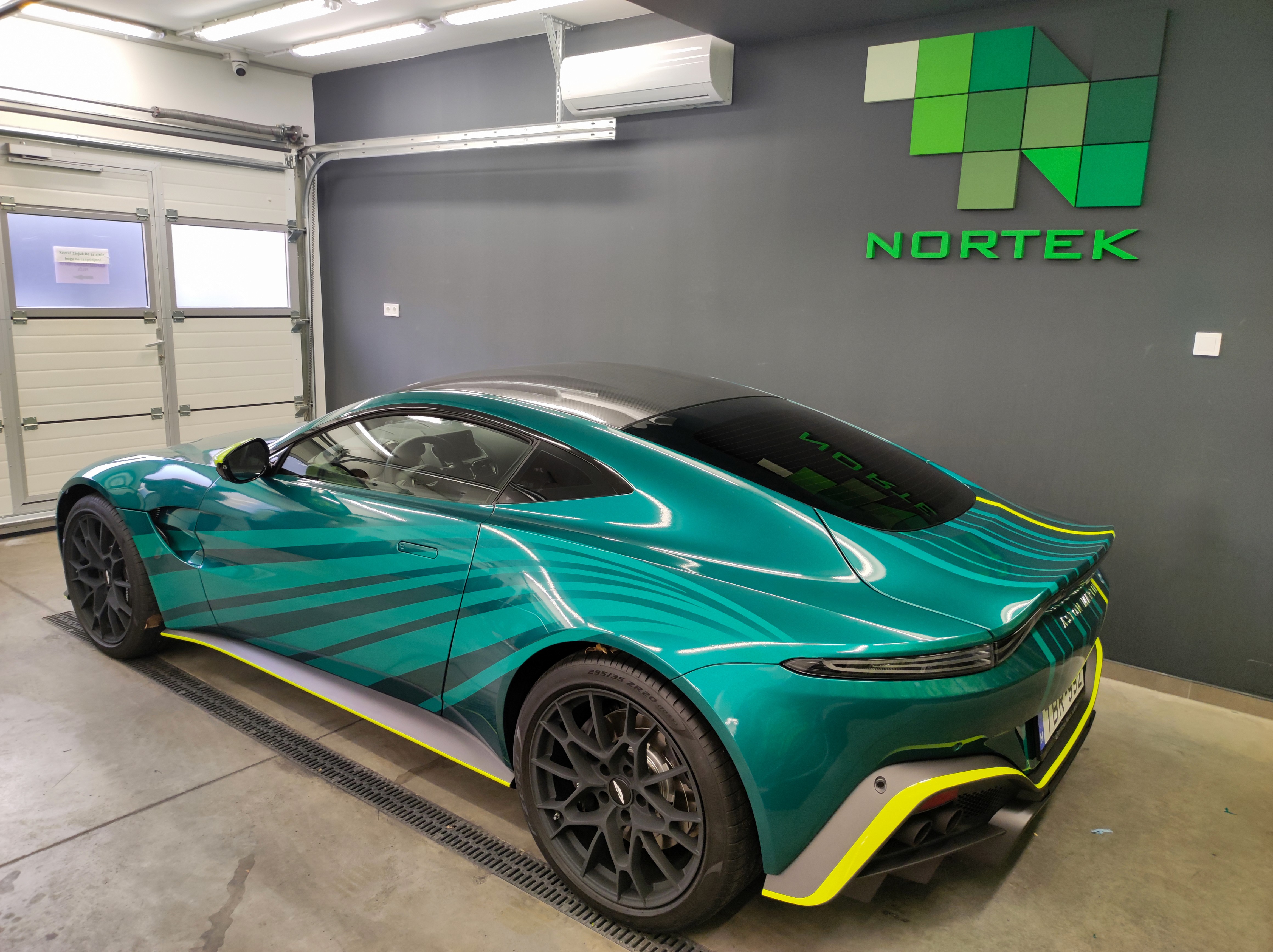 Egyedi tervezésű racing livery autógrafika egy Aston Martin Vantage hátulján. A hibátlan fóliaillesztések és a merész színkombináció garantálja a kitűnést a tömegből.