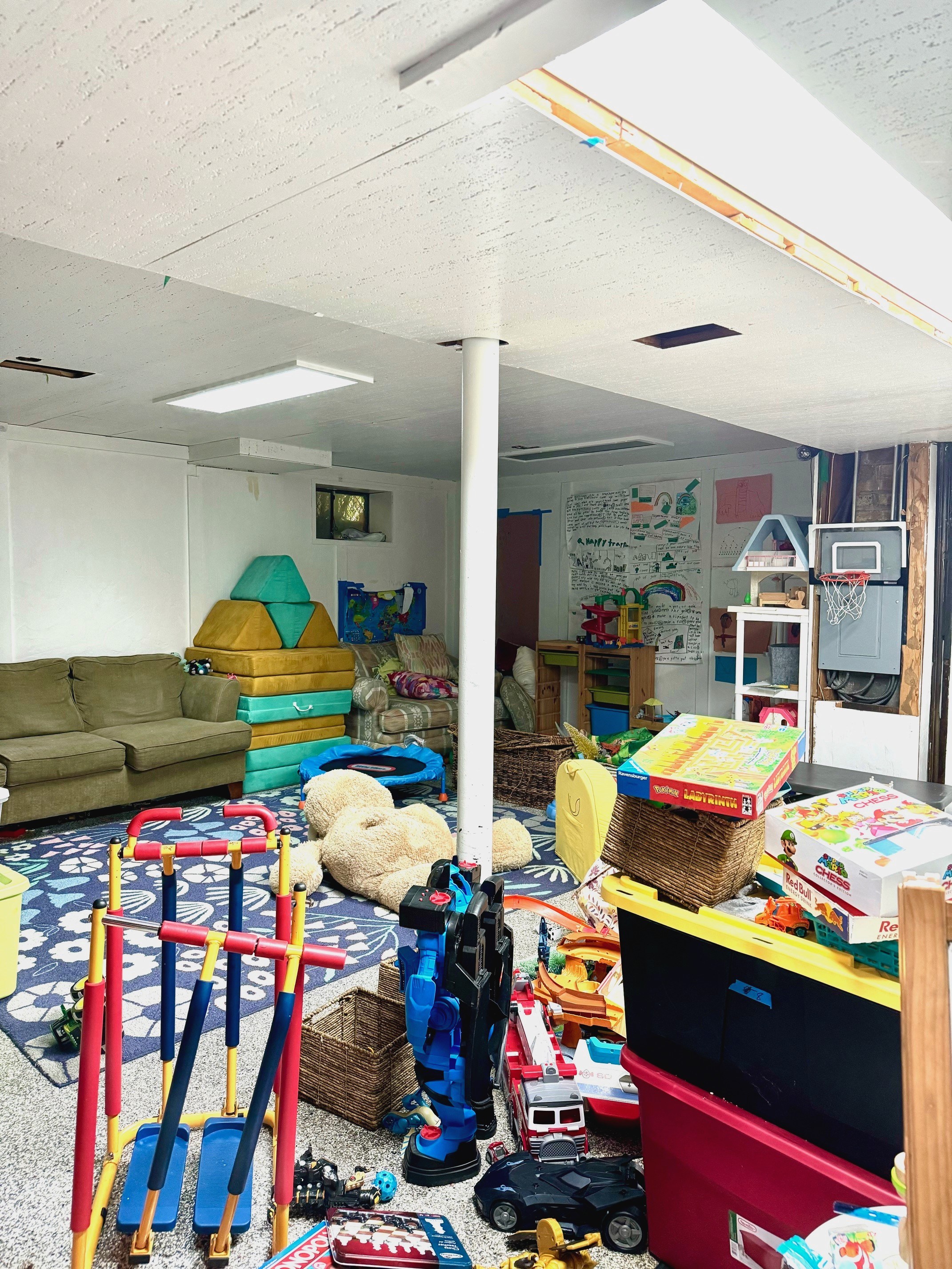 messy basement playroom colorful with rug and toys