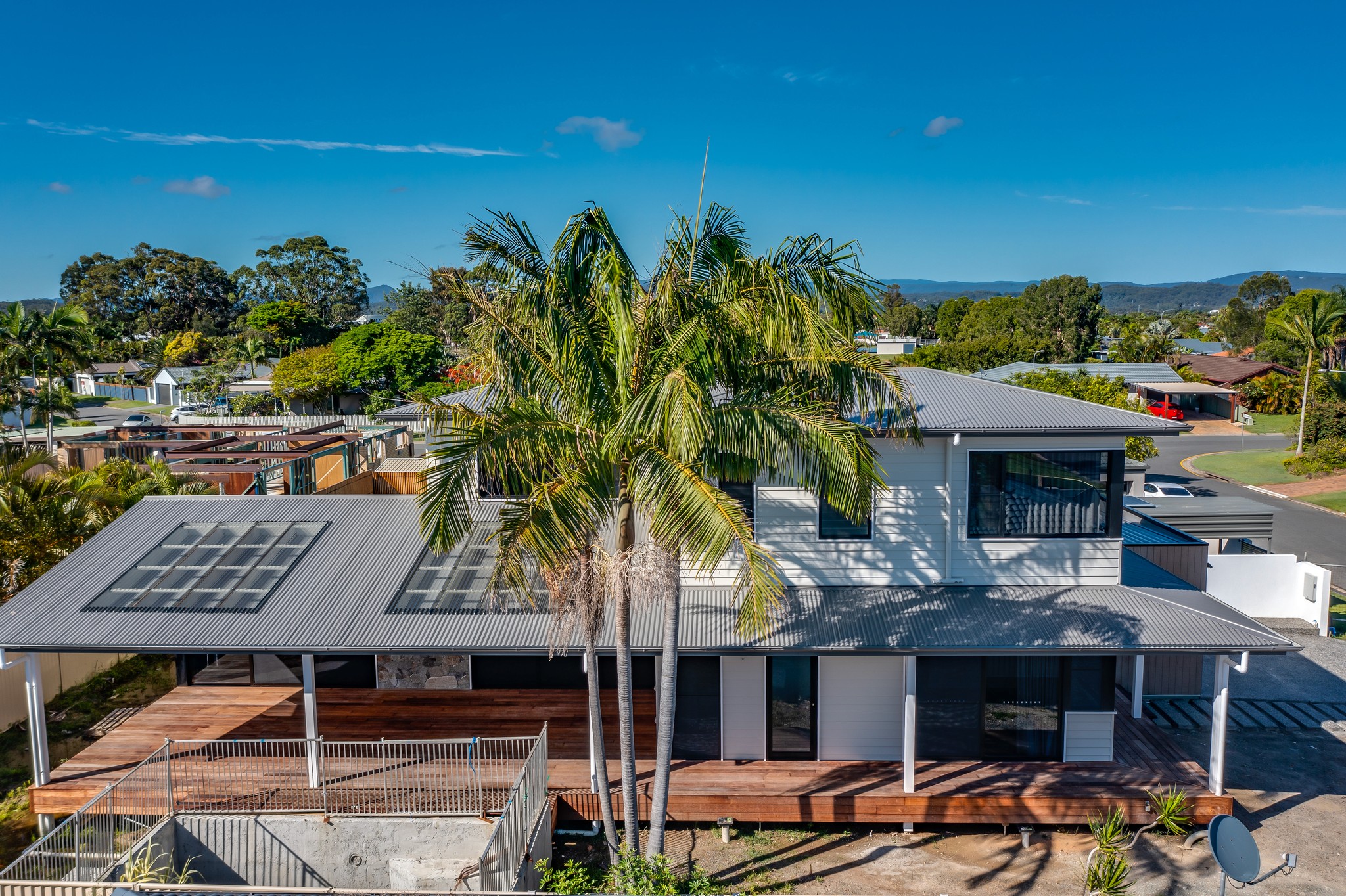 A winding road cuts through rocky terrain, surrounded by patches of green grass and illuminated by sunlight.