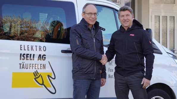 Daniel Iseli et Hans-Ruedi Minder se serrent la main devant un véhicule d'Elektro Iseli