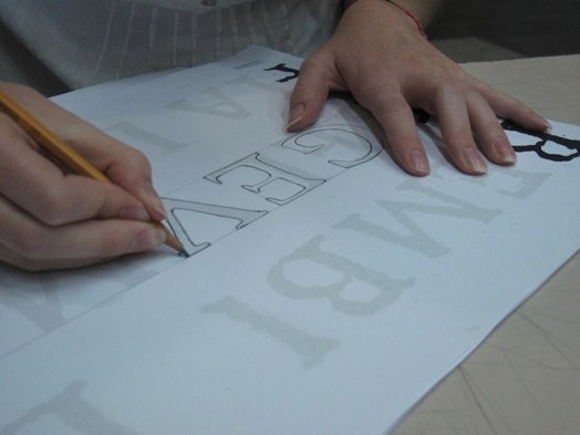 A photo of a letter being drawn by a student on a piece of paper.