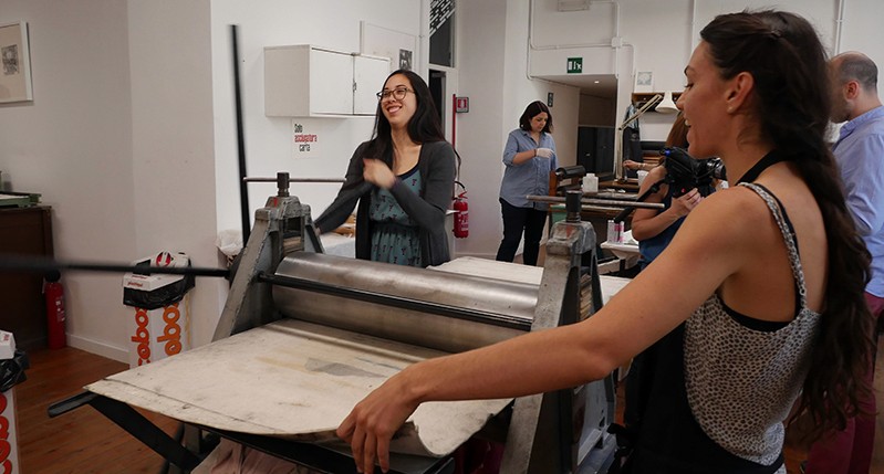 Students working on a pressing bench and making posters.