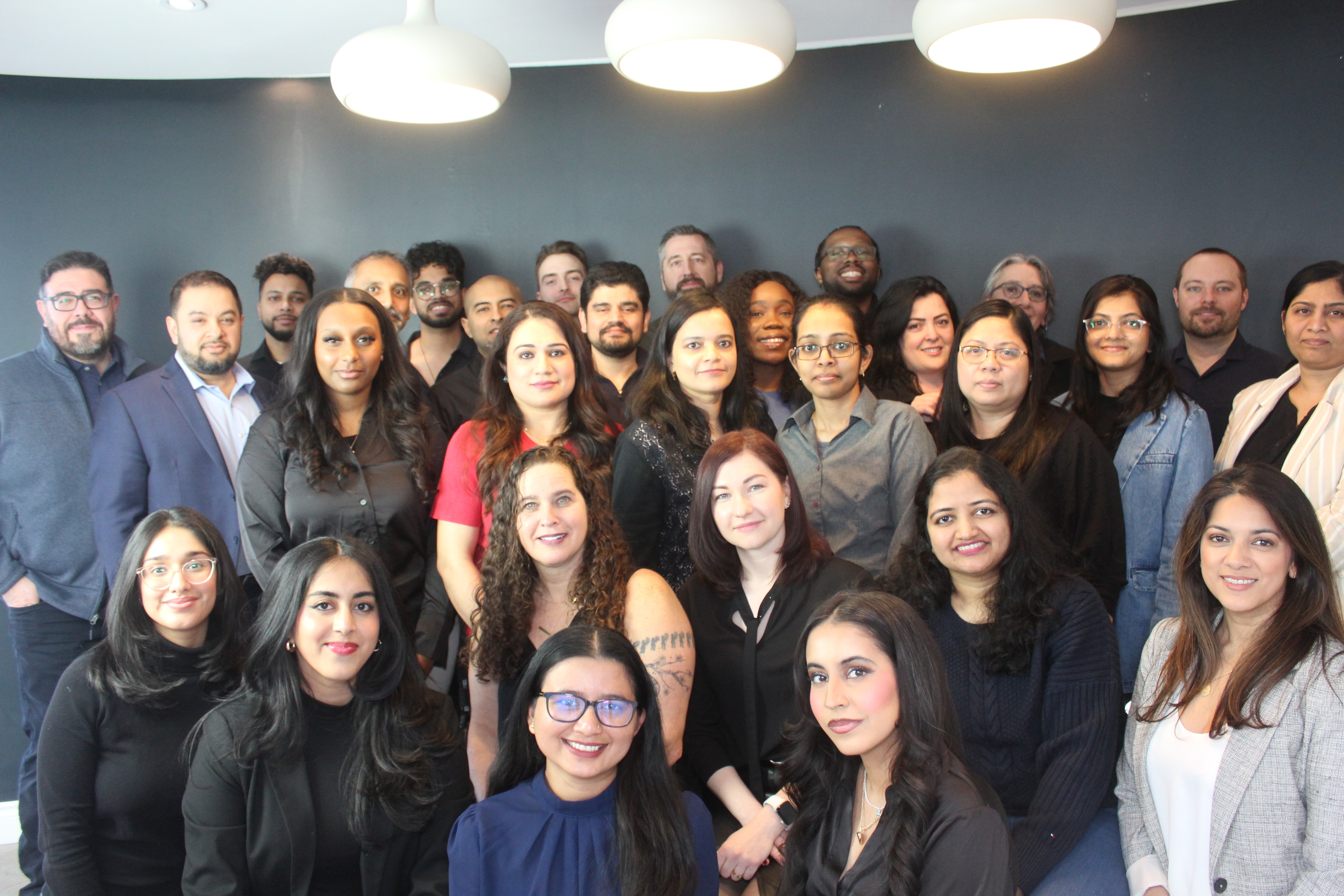 PaymentEvolution team photo showing diverse group of employees gathered in modern Toronto office