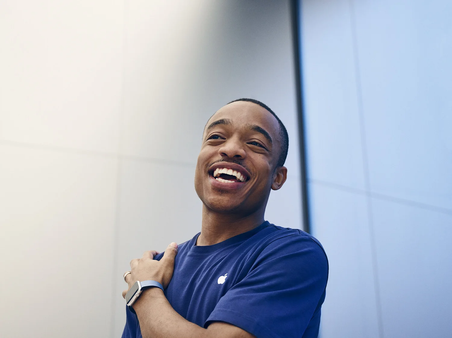 Smiling Apple employee featured in the Unbox Yourself employer brand campaign.