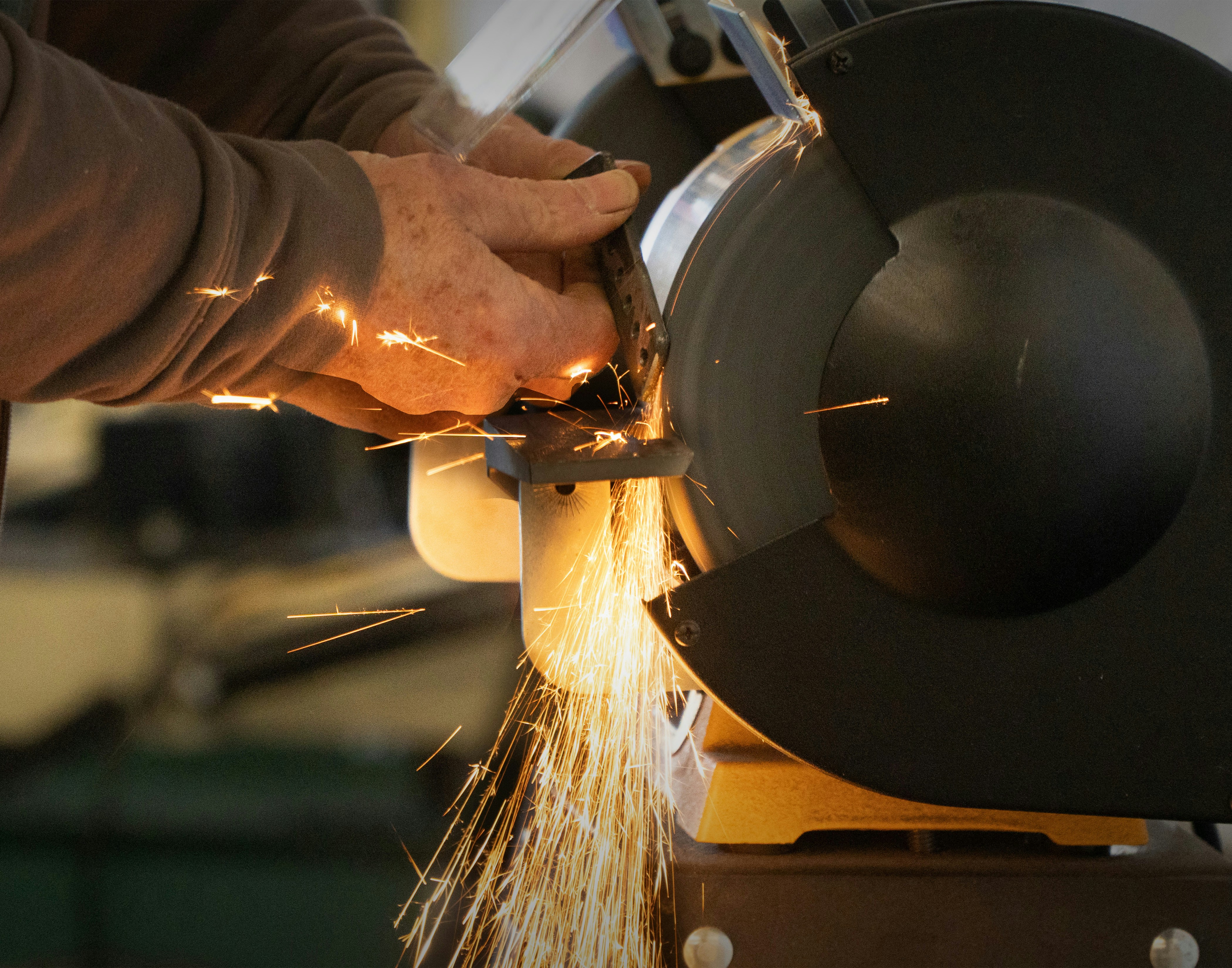 A person grinding metal with a grinder