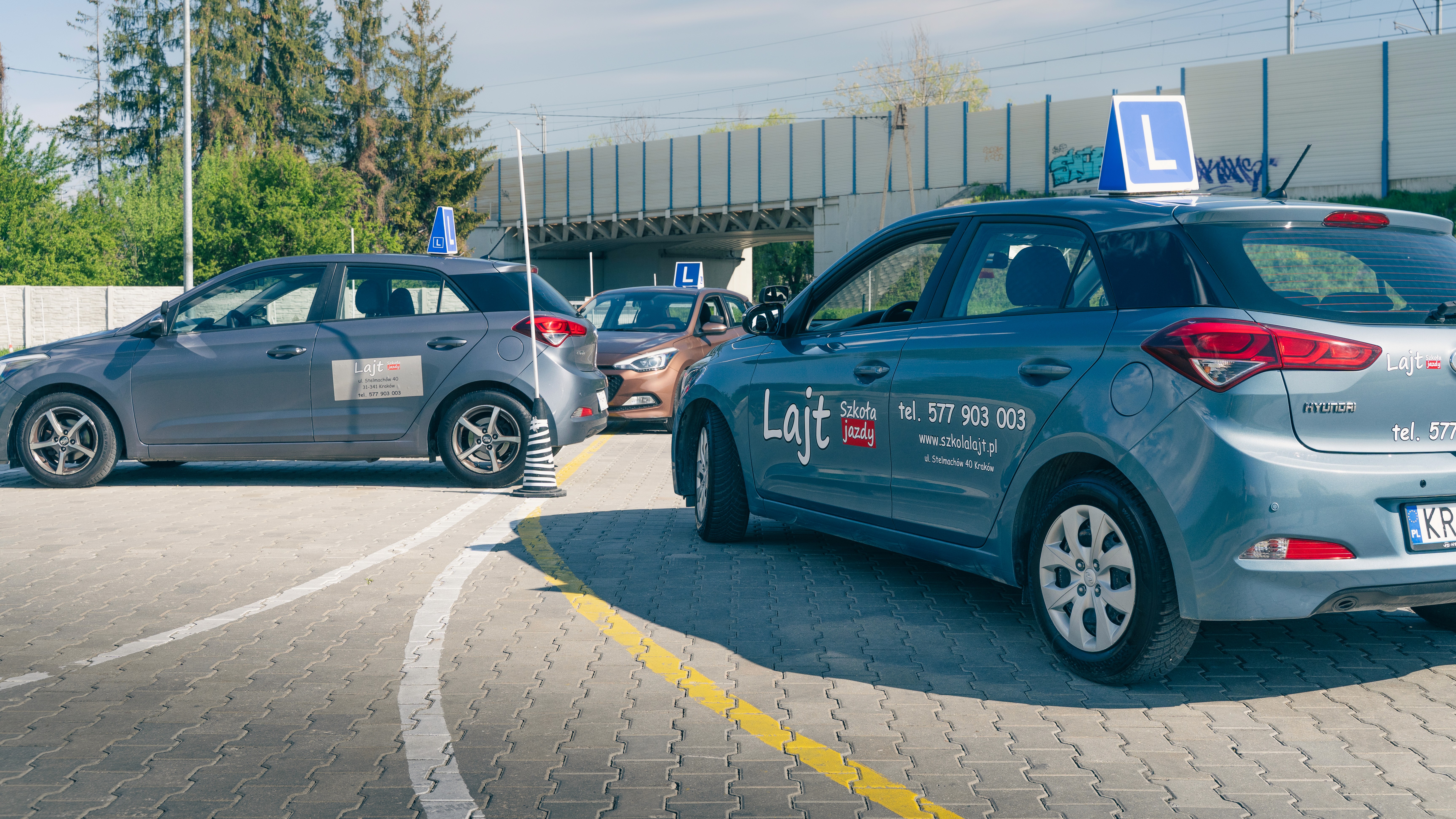 Samochody OSK Lajt Kraków z tablicami „L” na placu manewrowym szkoły jazdy