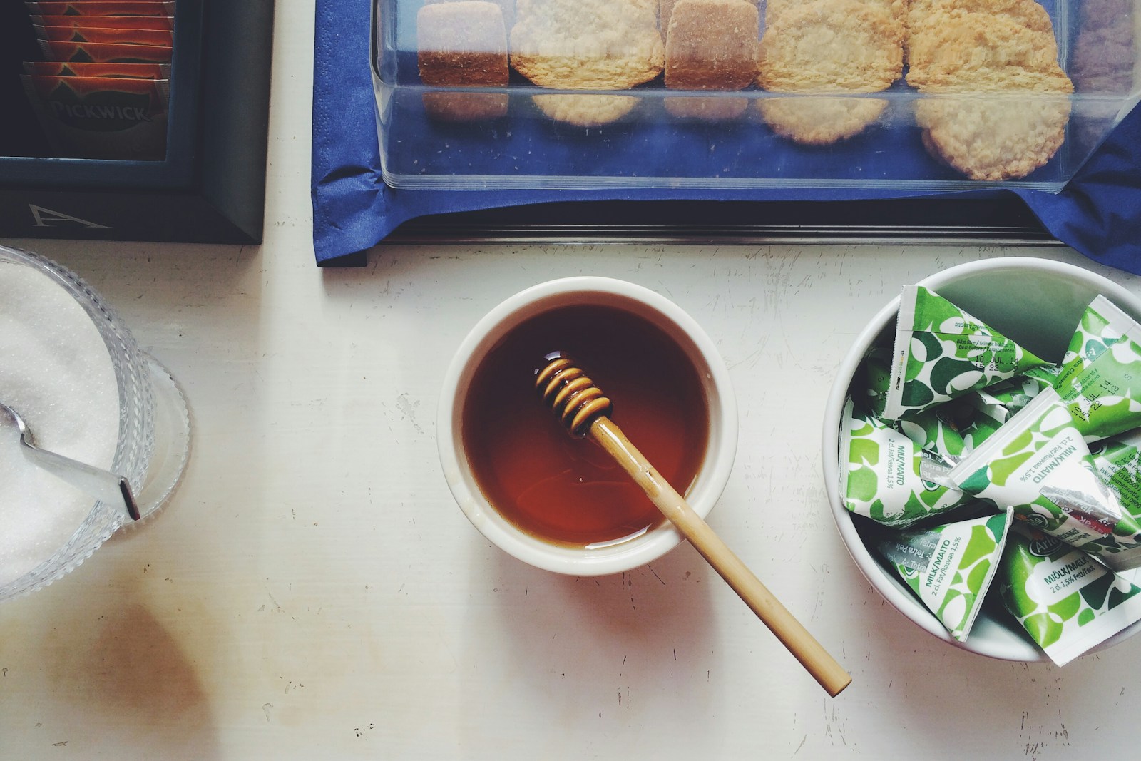 A warm cup of tea with honey beside plain cookies, gentle, easy foods for days when appetite and taste change during treatment