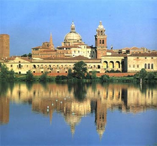 A photo of an old stone building reflected into a nearby lake.