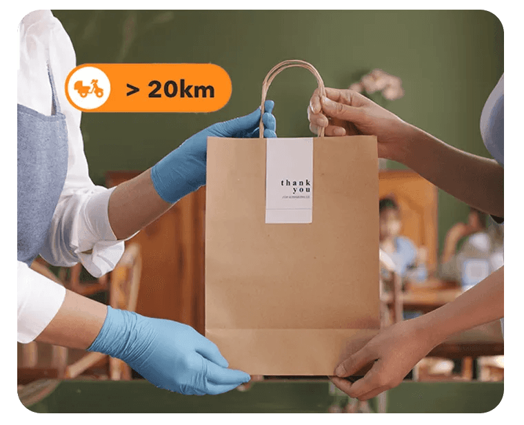 Malaysian F&B staff handing over a takeaway order prepared through StoreHub online ordering with extended delivery coverage.