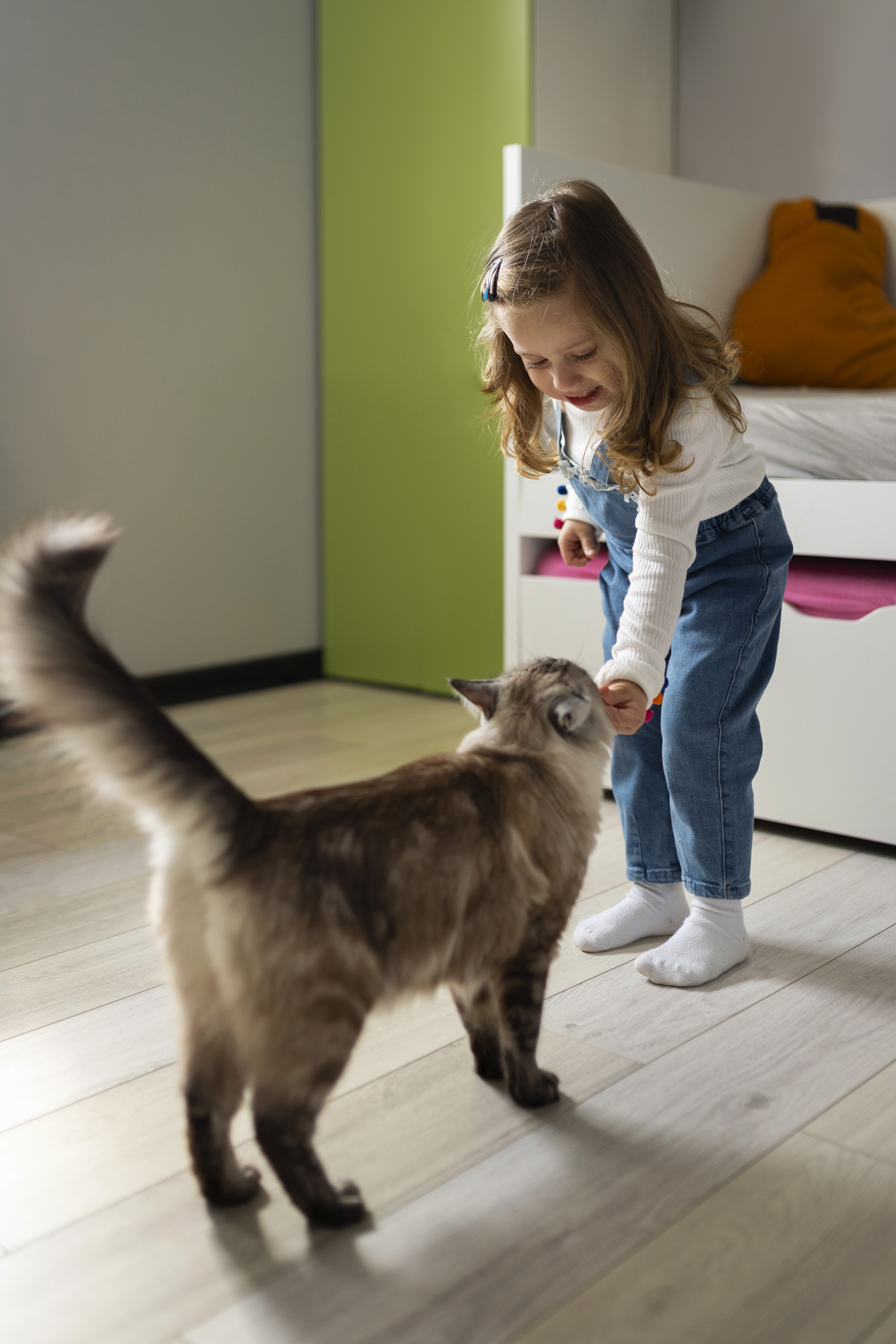 A young child gently plays with a cat on LUXO’s light wood-look hybrid flooring, showcasing a safe, scratch-resistant, and pet-friendly surface designed for comfortable everyday living in Australian homes.