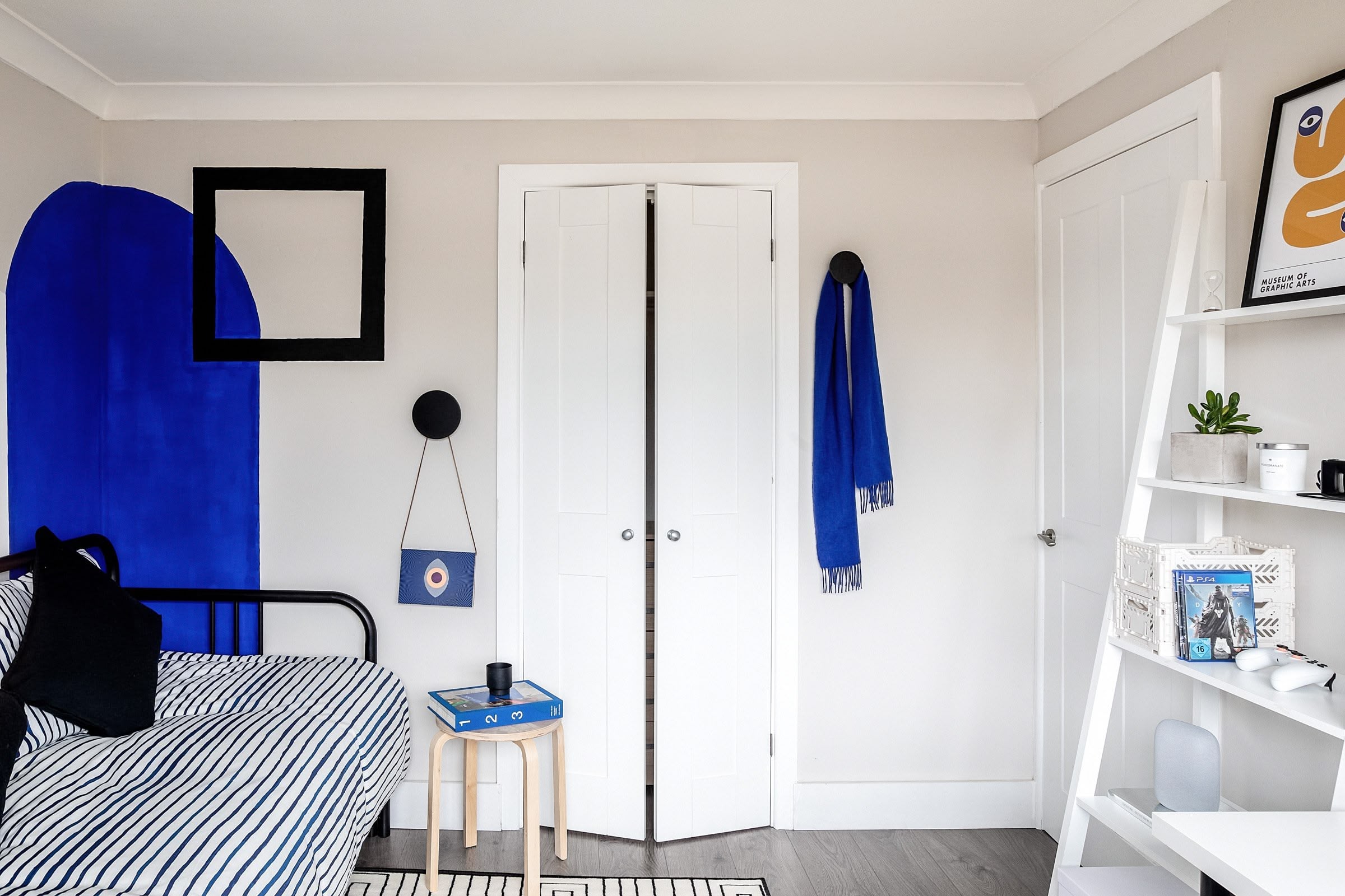 Colourful blue and neutral bedroom with custom-painted features, patterned textiles, and playful design elements, Atelier Akuko