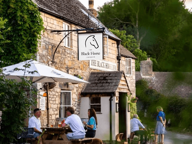 A close-up of a hand wearing multiple decorative rings against a blue background.