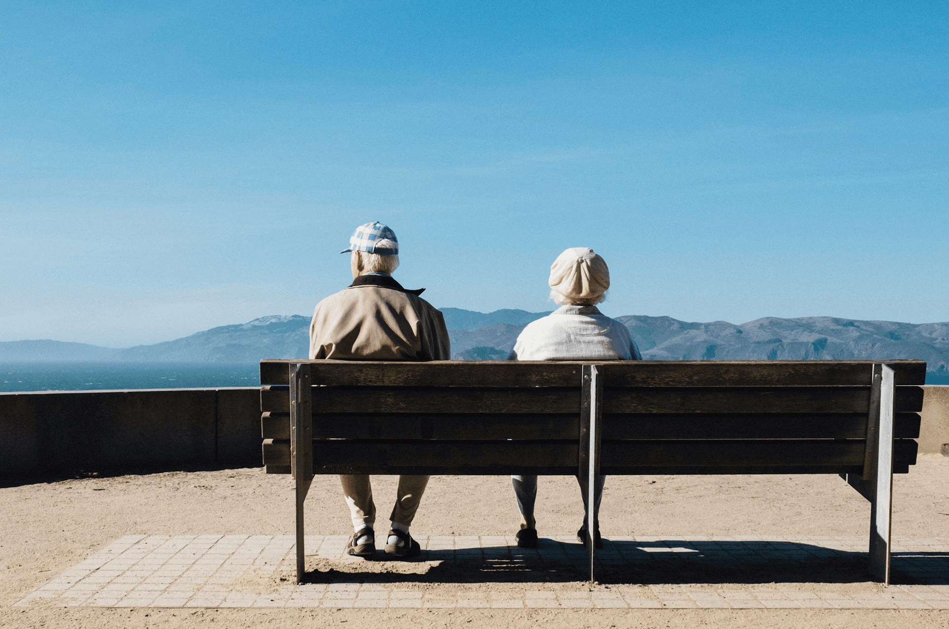 Two people sitting on a bench overlooking the sea, symbolizing a founder content system that builds B2B pipeline through LinkedIn authority