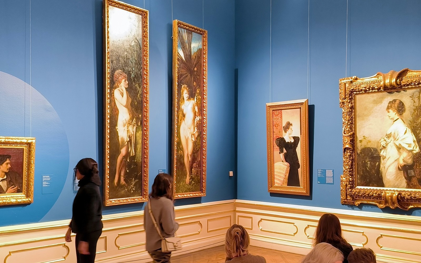 Επισκέπτες που παρακολουθούν πίνακες ζωγραφικής σε μια ξενάγηση στην Αίθουσα Τέχνης του Άνω Μπελβεντέρε.