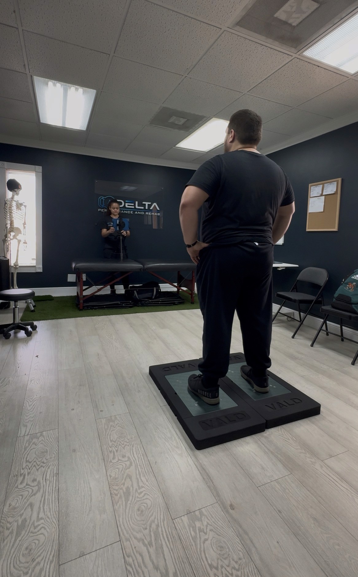 Wide-angle view of a packed sports stadium during a live athletic event, featuring a red running track and green field under dramatic skies at sunset.