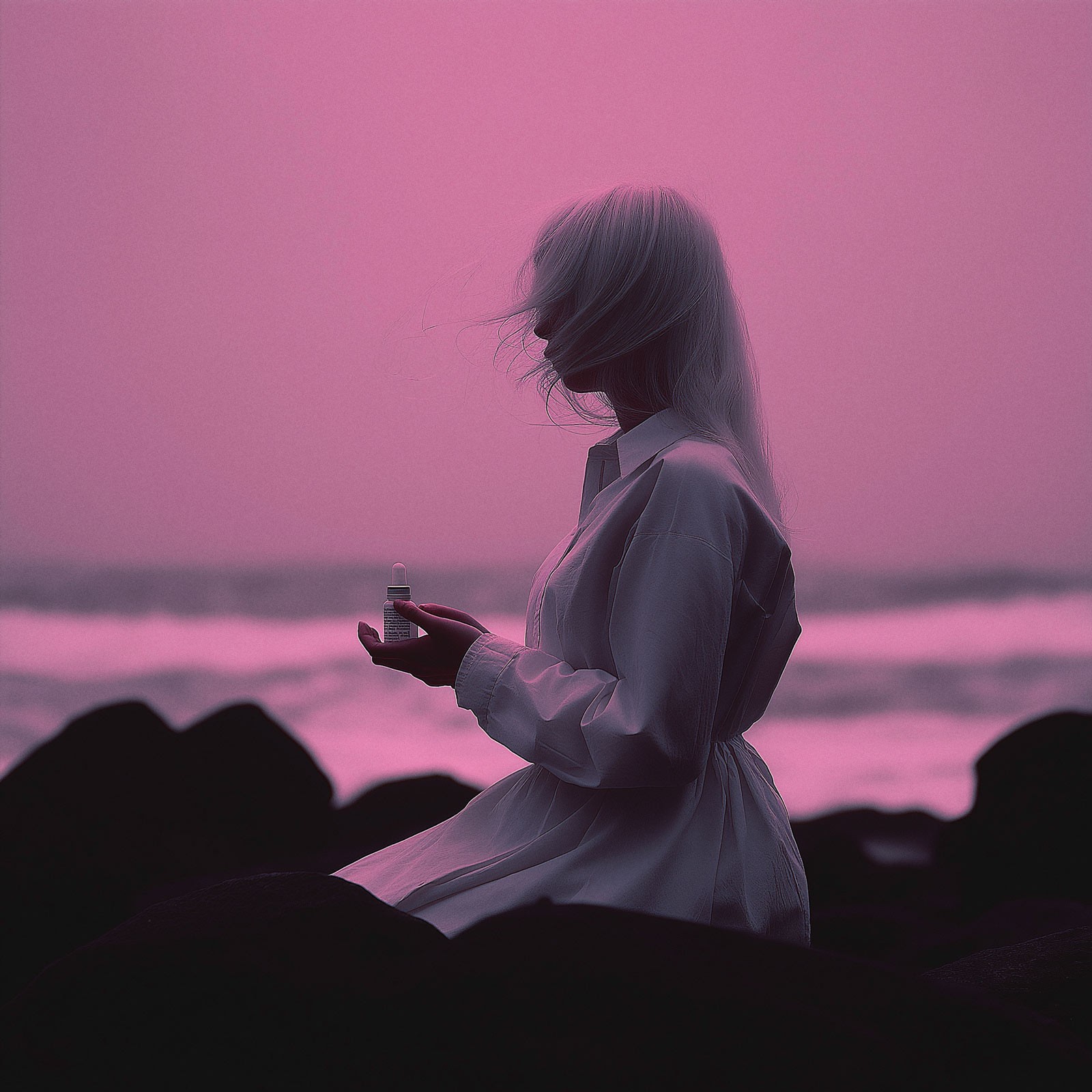 Woman silhouette on beach in pink-purple tones
