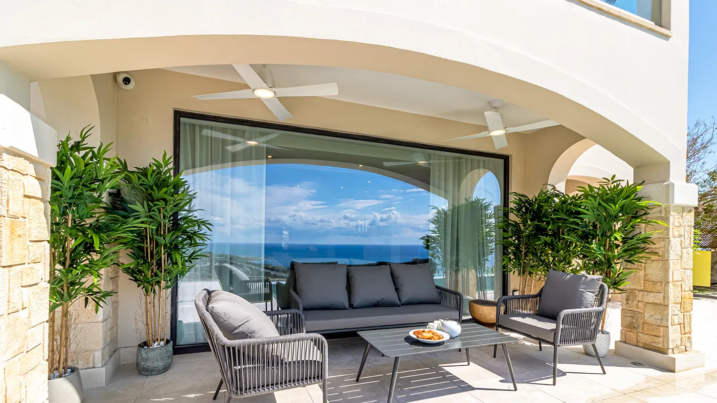 White Cedar House Mediterranean covered terrace with outdoor lounge seating and panoramic sea views