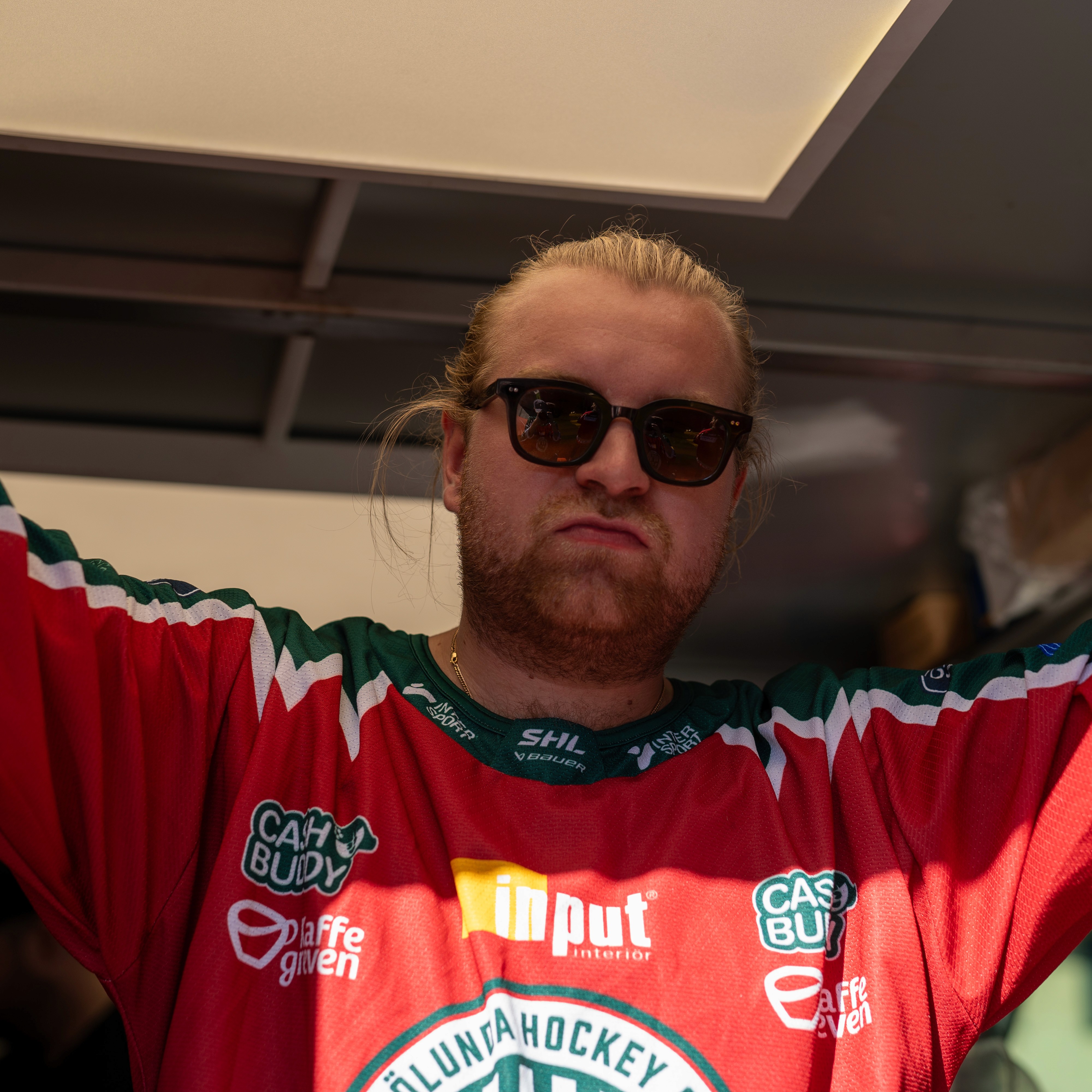 A person's hands adjusting a black ribbon on a white jacket on a mannequin