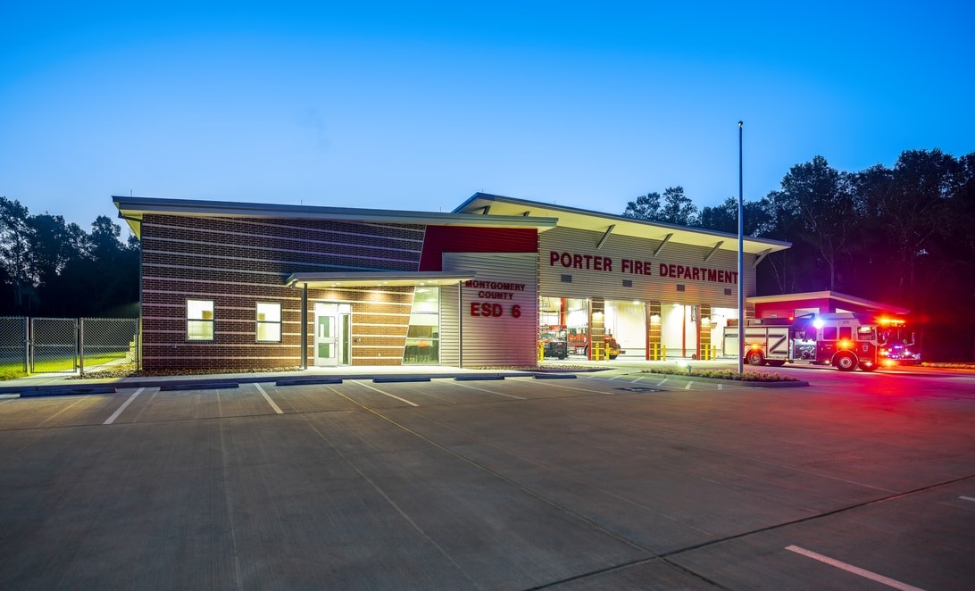 Dusk exterior with fire engine and emergency lights at MCESD 6 Fire Station 122, by Martinez Architects.