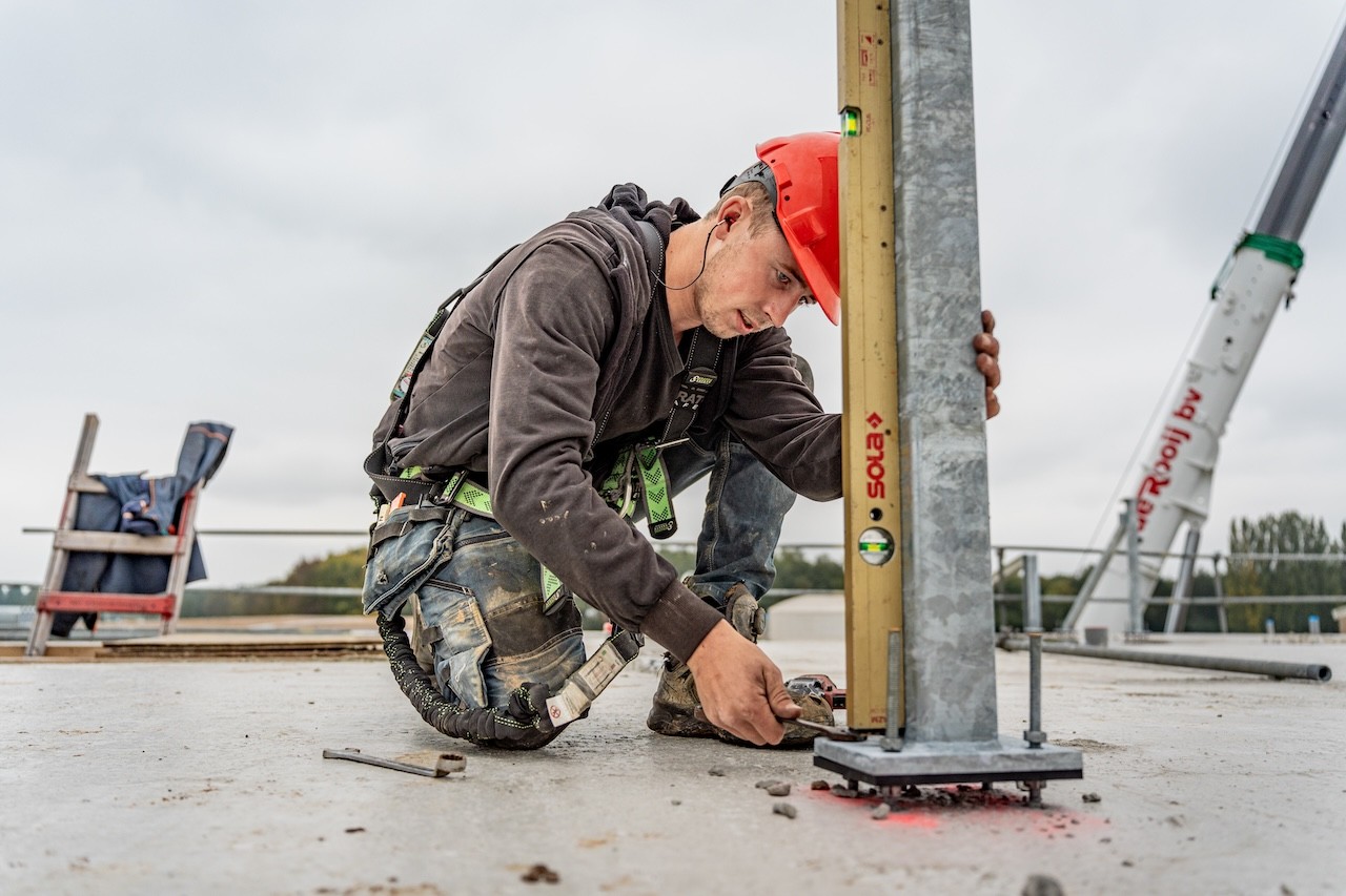 Montagemedewerker met rode helm op de bouw- Steeg en van Harten