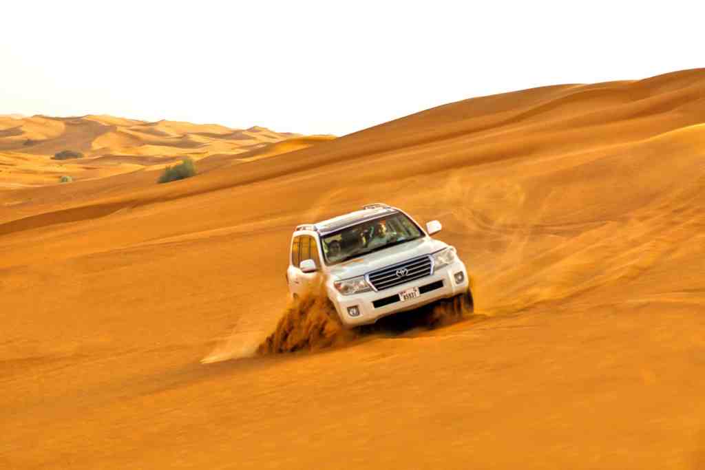 jeep driving through the desert, dubai