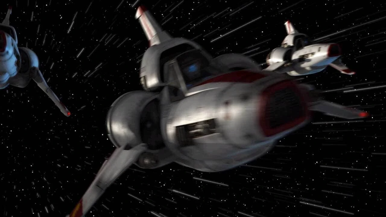 Three futuristic spacecraft zoom through a star-filled space background. The ships have sleek designs with red and white markings, and a central cockpit area. Trails behind them suggest high speed.