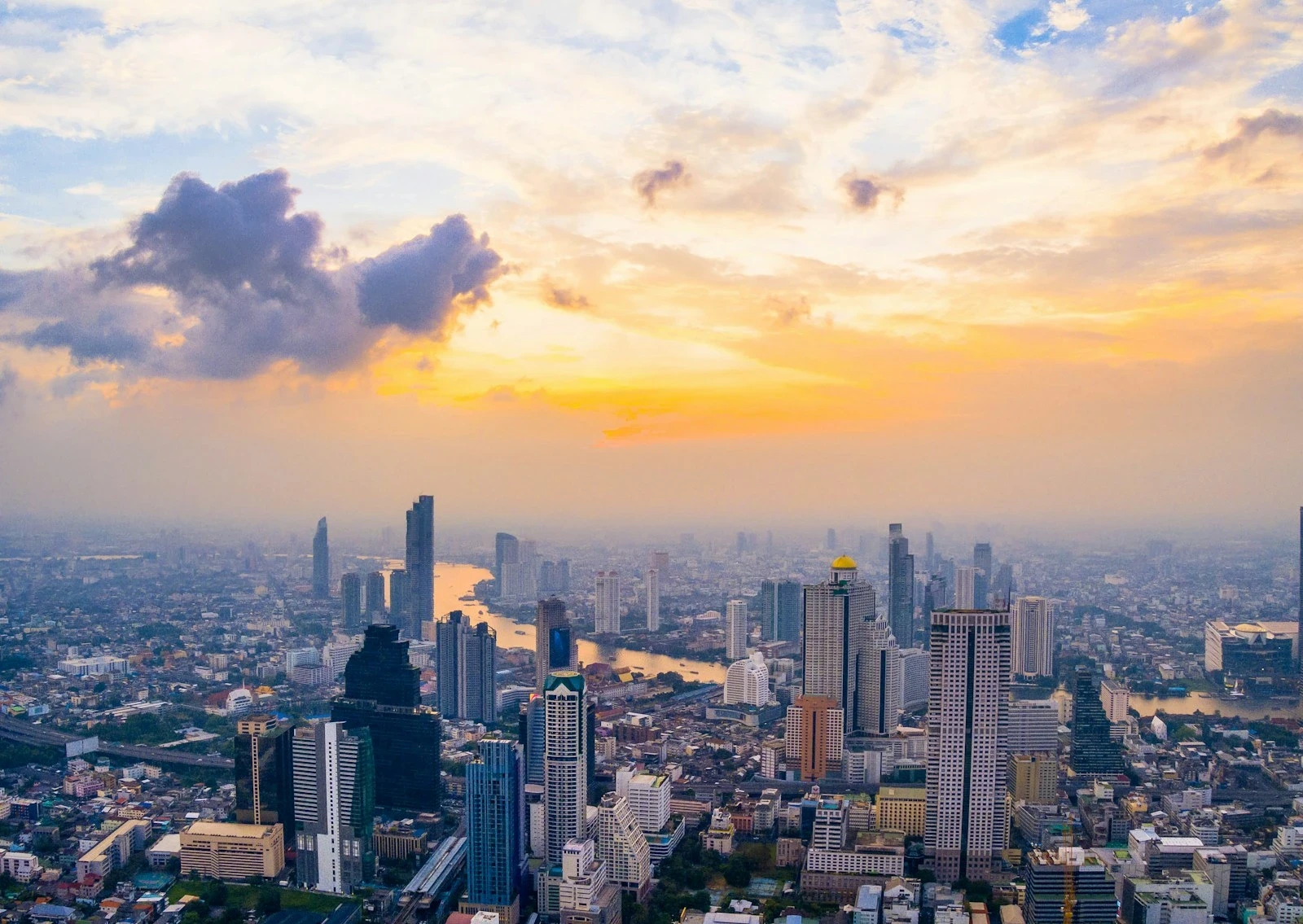 Aerial view of the Bangkok skyline at sunset with the Chao Phraya River