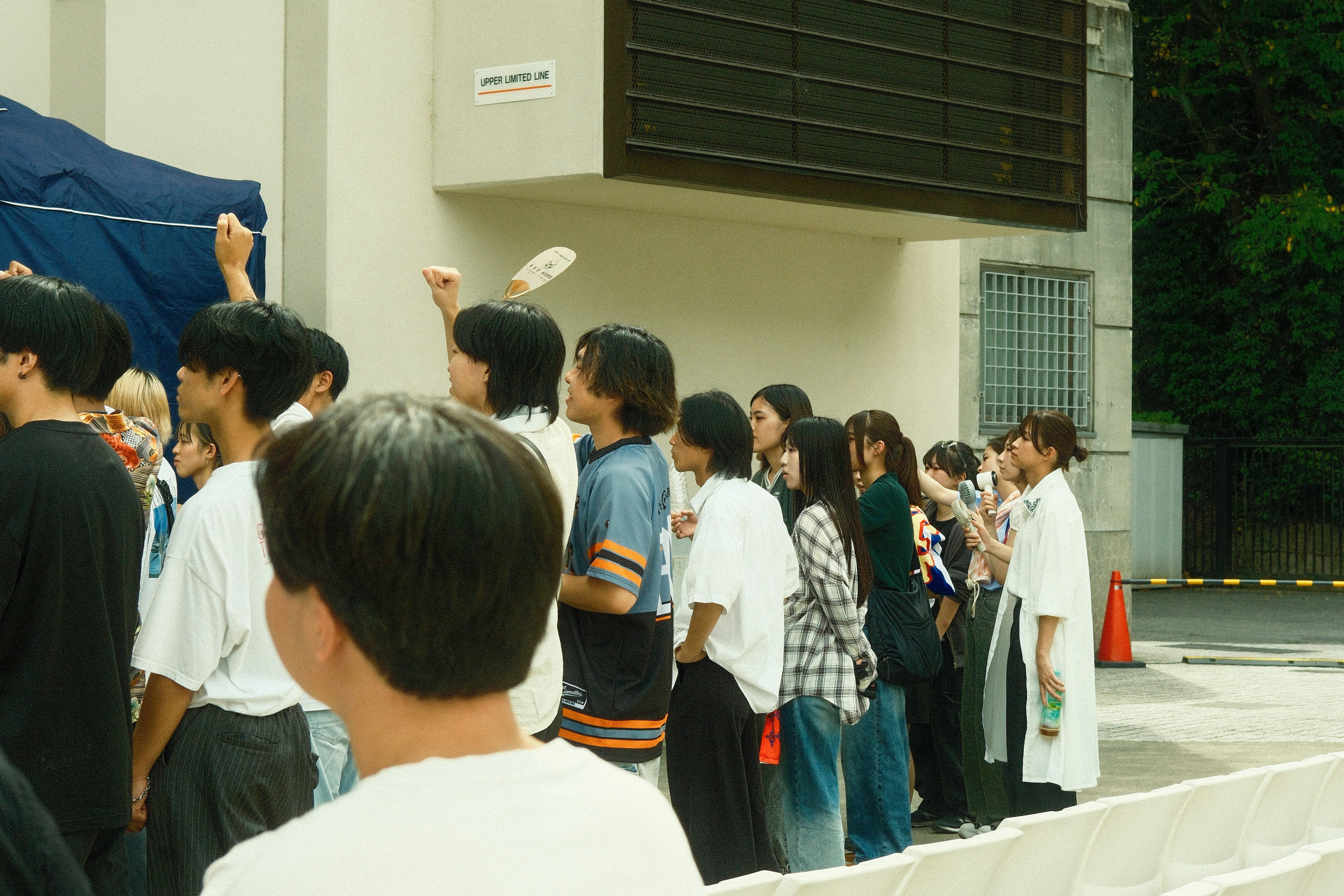 A diverse group of people standing in a line outdoors.