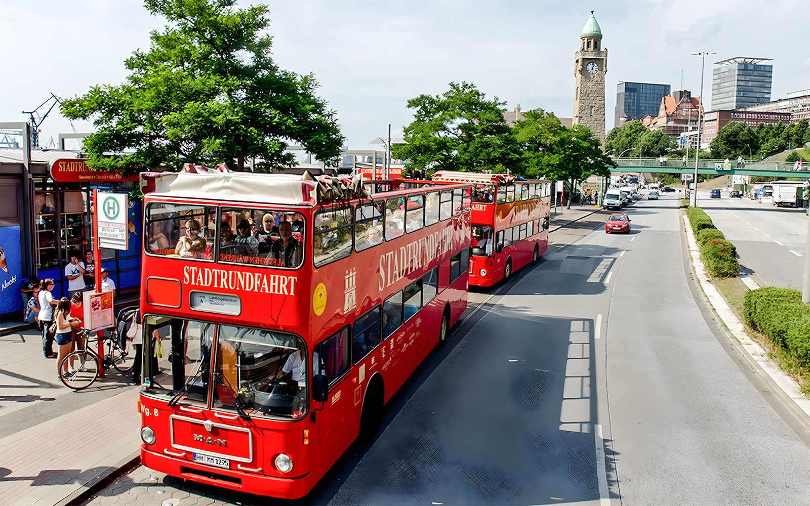 Red double-decker tour buses in Hamburg near St. Michael's Church, part of the Hamburg City Pass experience.