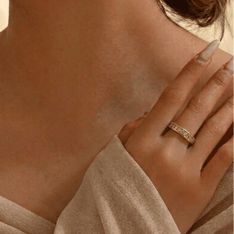 Woman's hand wearing the Gilded Eternity Band in yellow gold