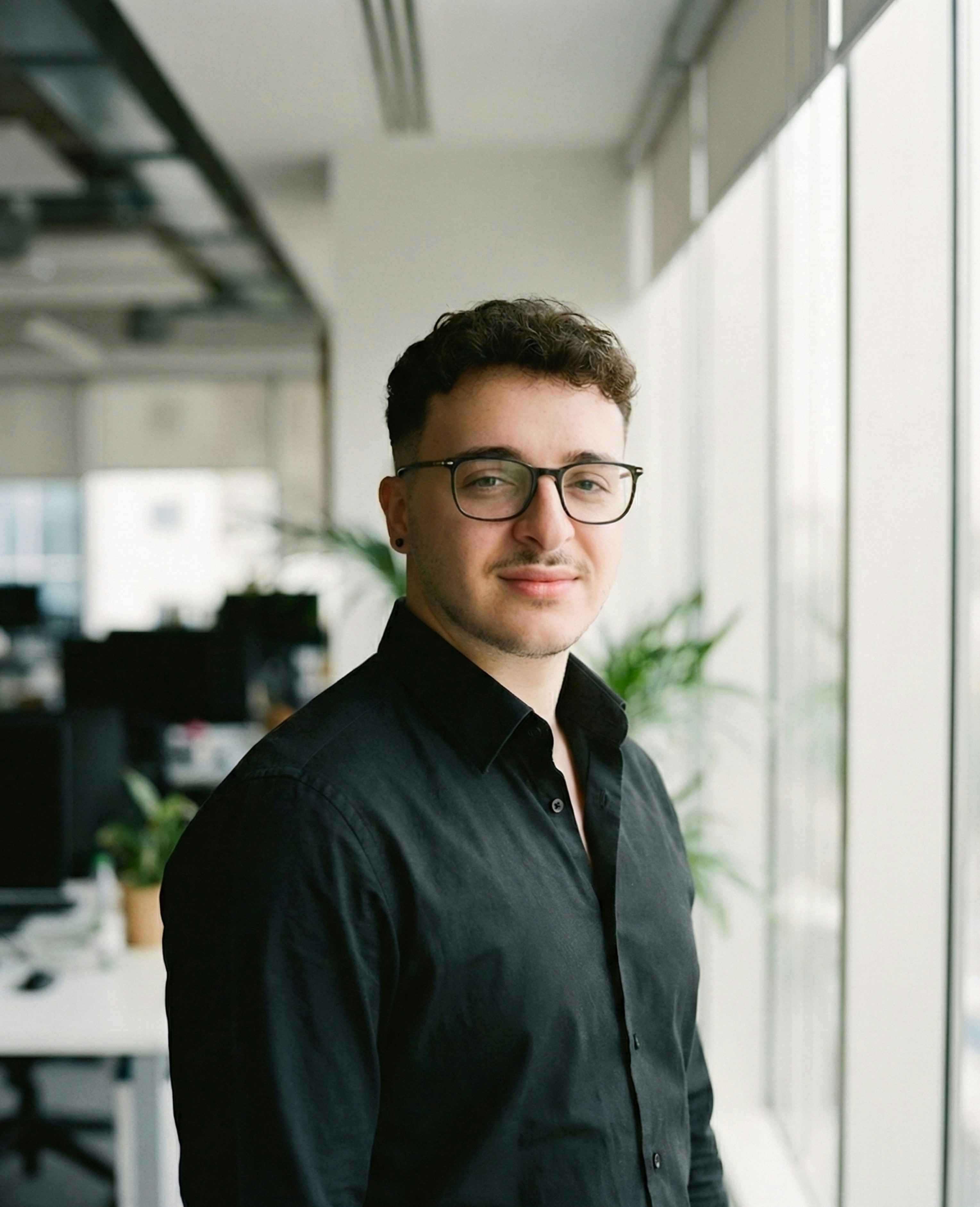 Young man in glasses wearing a black shirt indoors