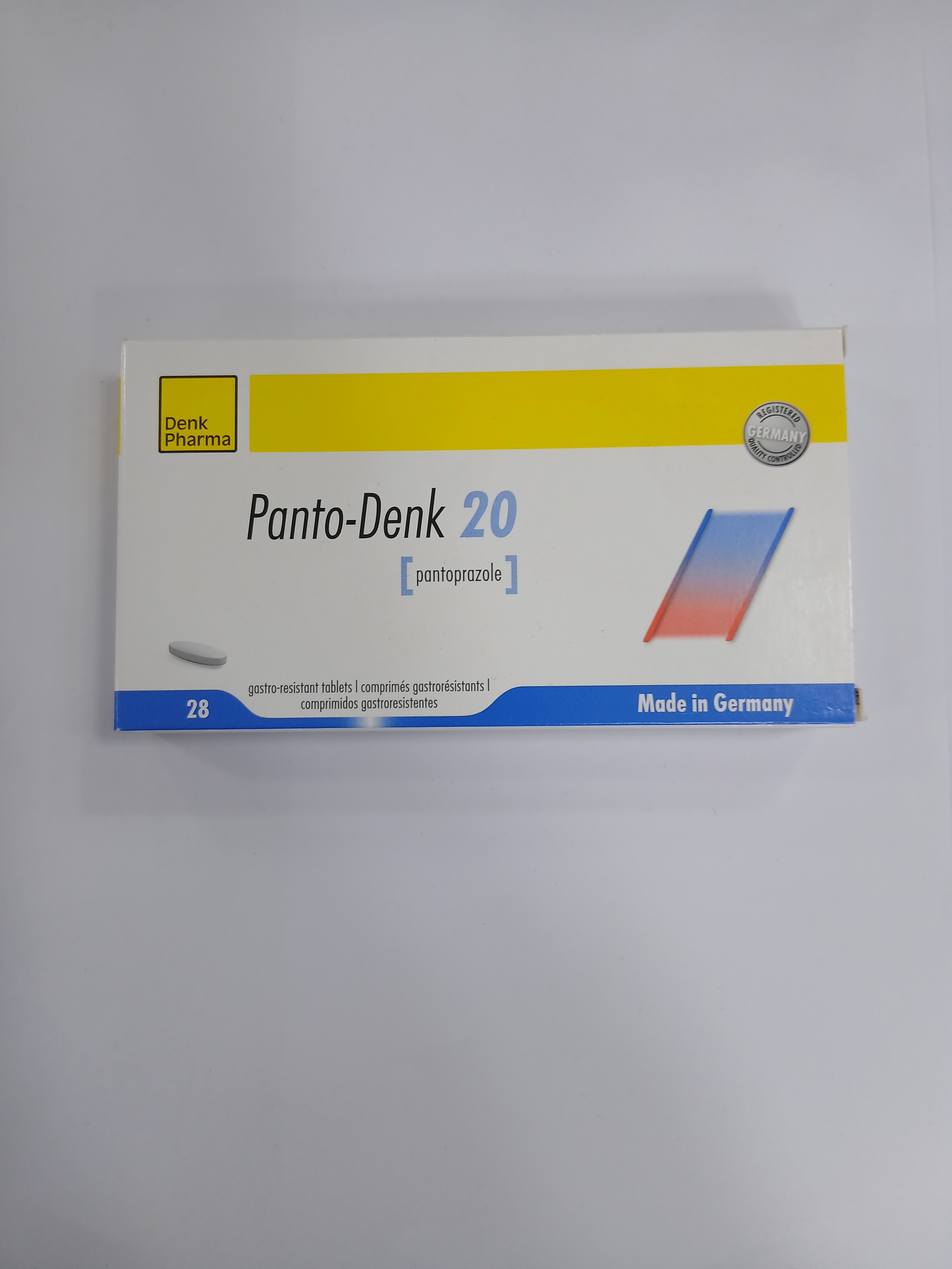 A clear plastic blister pack with a yellow and blue label sits on a plain background, containing 28 small white pills.