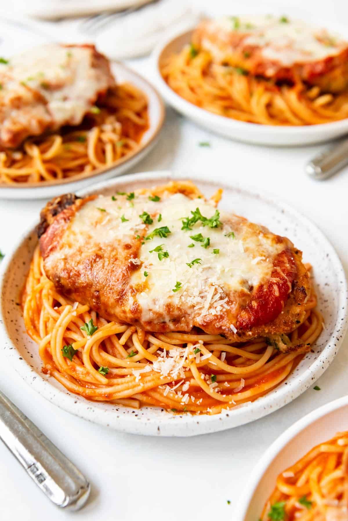 Chicken Parmesan from Pasta 9 Toronto served with linguini in rosé sauce topped with baked breaded chicken, mozzarella, and Parmesan.