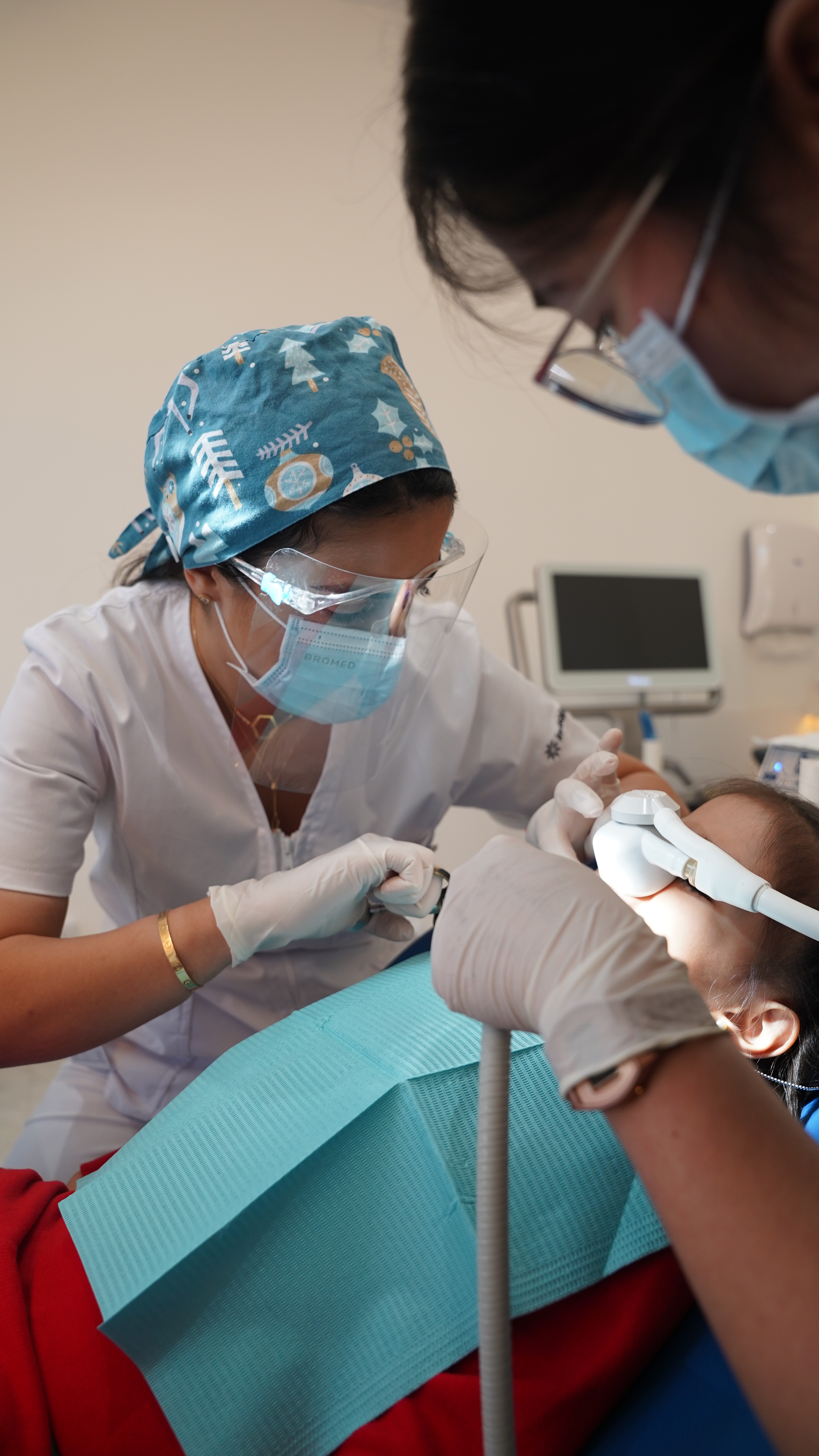 طبيبة بعيادة أسنان الأطفال بمركز انفزلاين ومساعدتها تقومان بتخدير طفل لضمان جلسة علاجية مريحة وخالية من التوتر طوال الإجراء.