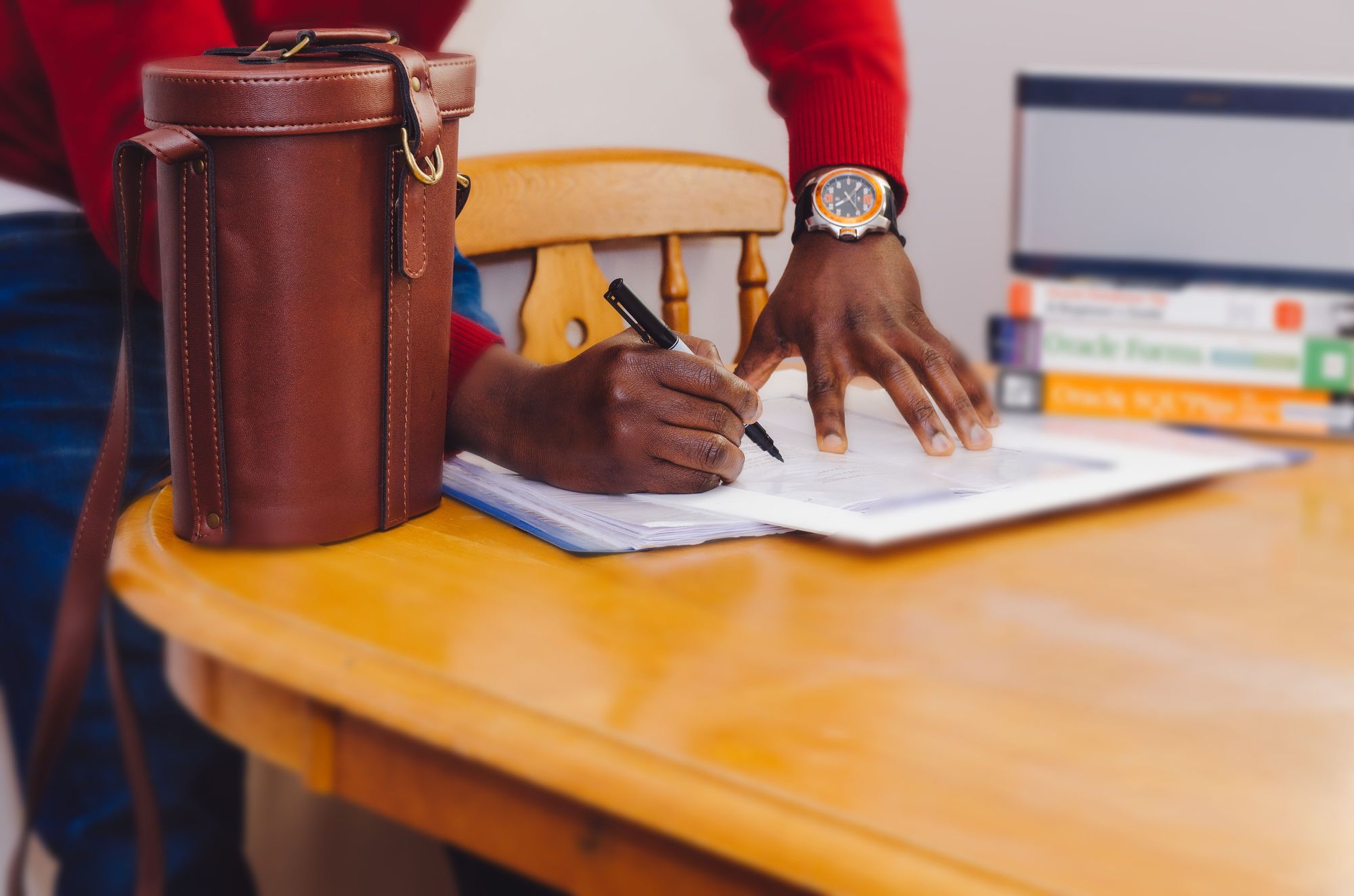 Man wearing watch writing on a table