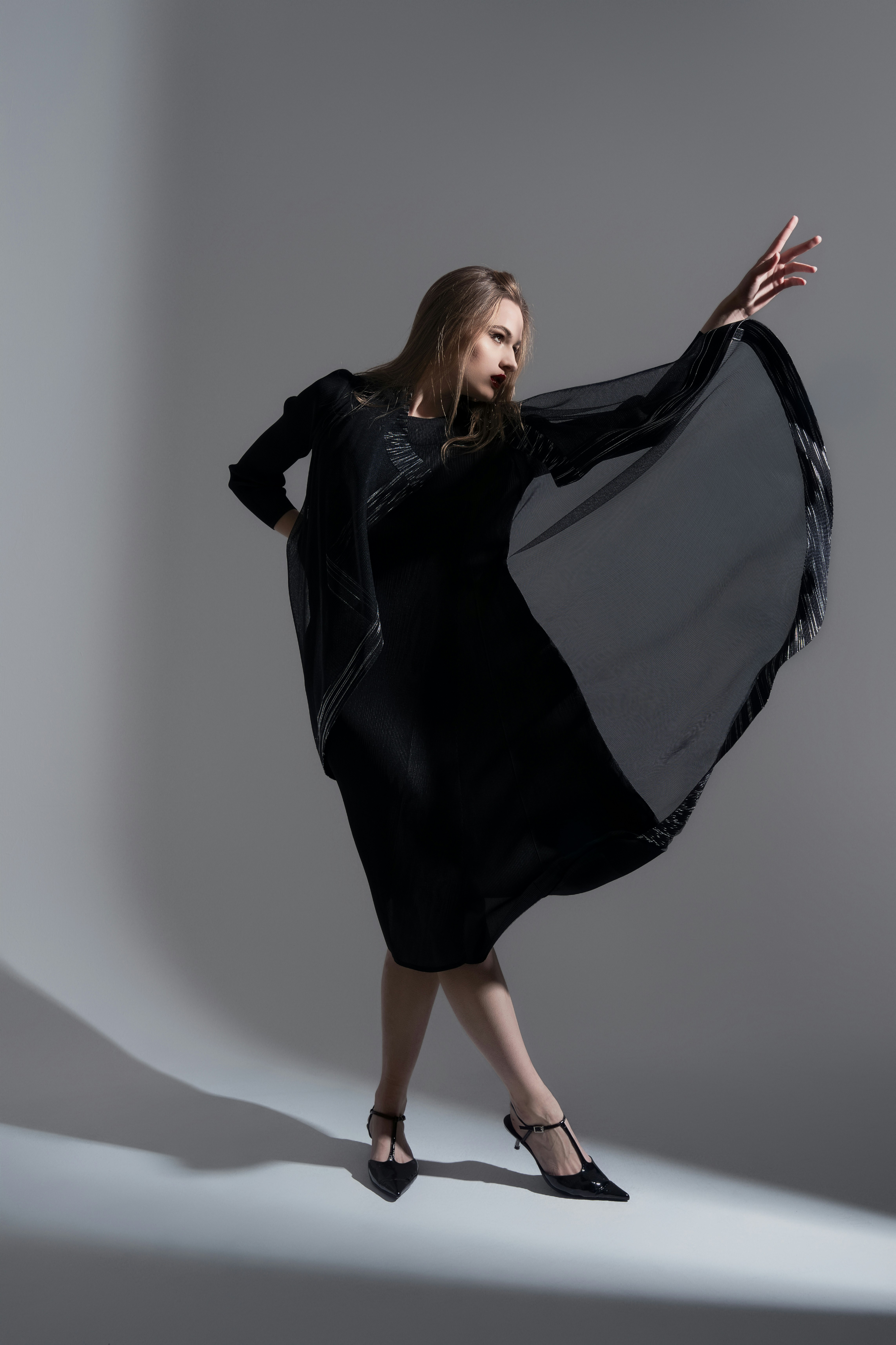 A woman in a black dress is posing for a picture