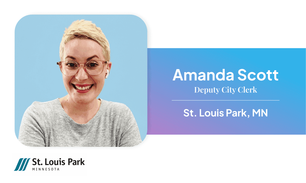 Female municipal clerk seated at office desk with nameplate reading 'Amanda Scott, City of St. Louis Park,' with office décor visible in the background