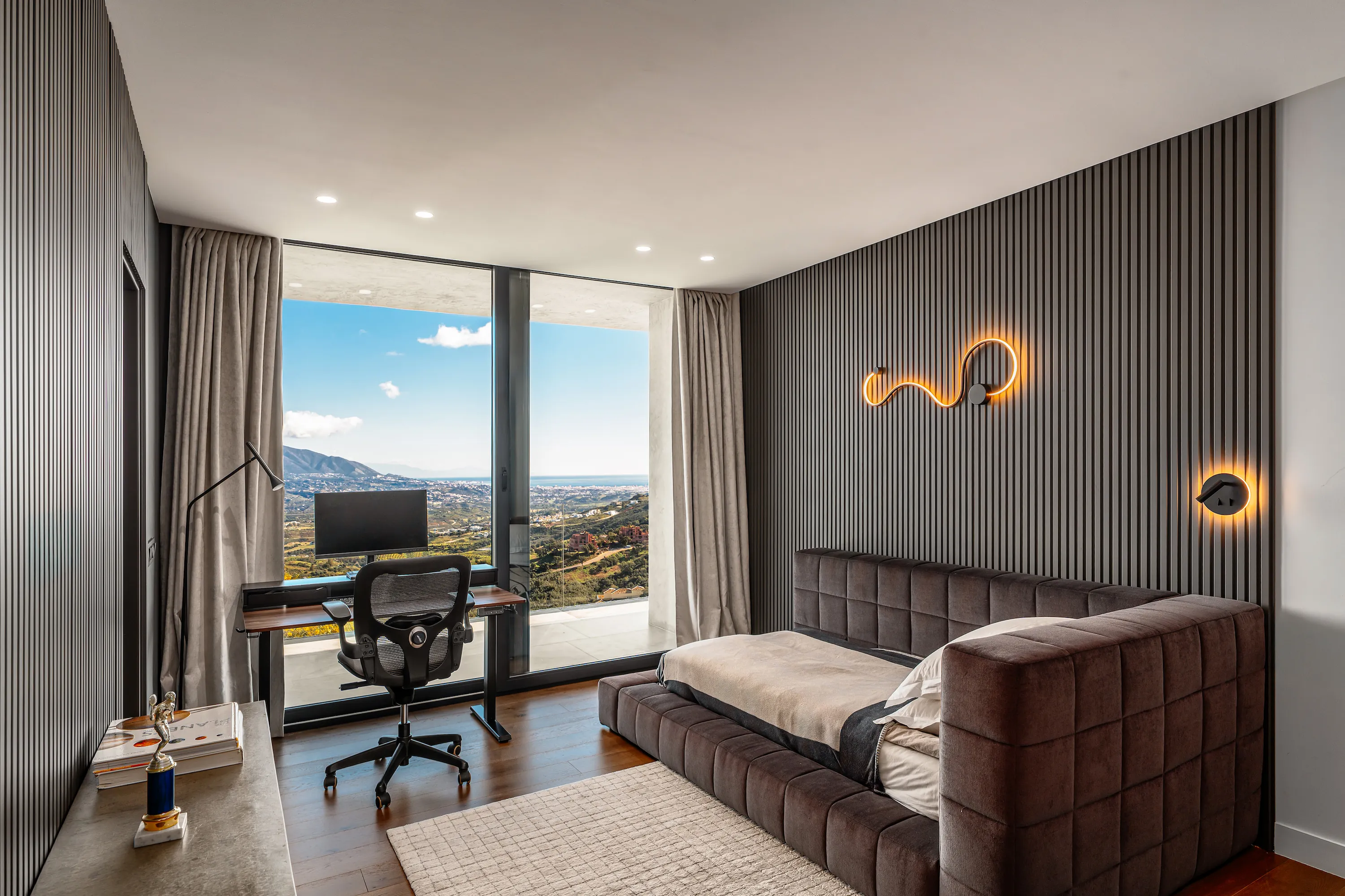 Villa Vista Marbella guest bedroom with fluted feature wall, built-in desk, and panoramic views