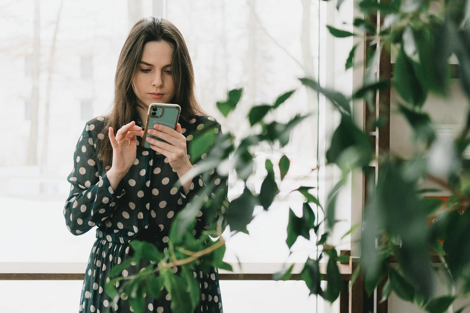 women in green shirt sing mobile phone
