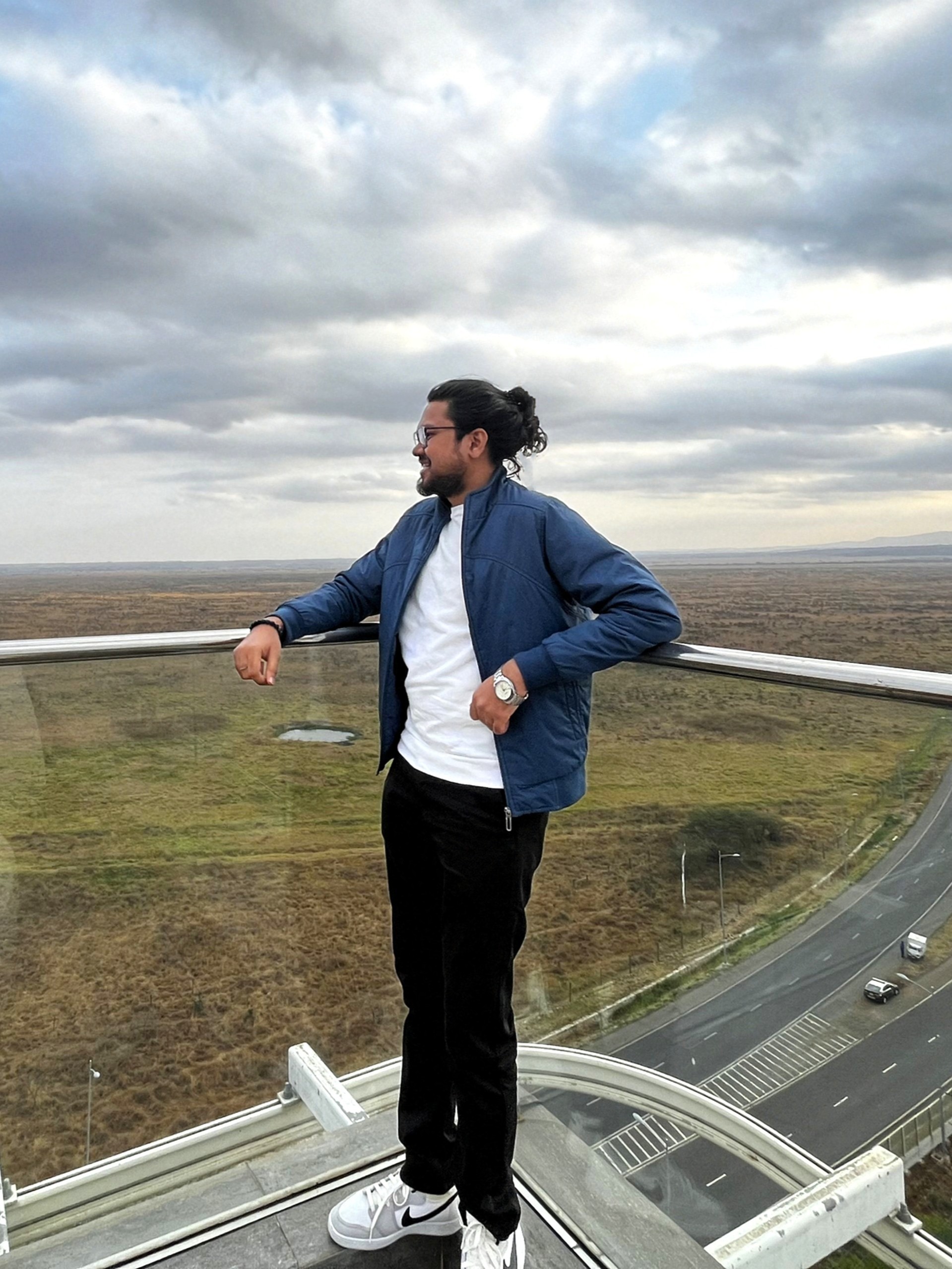 Shantanu Bahadure standing on a balcony overlooking a highway