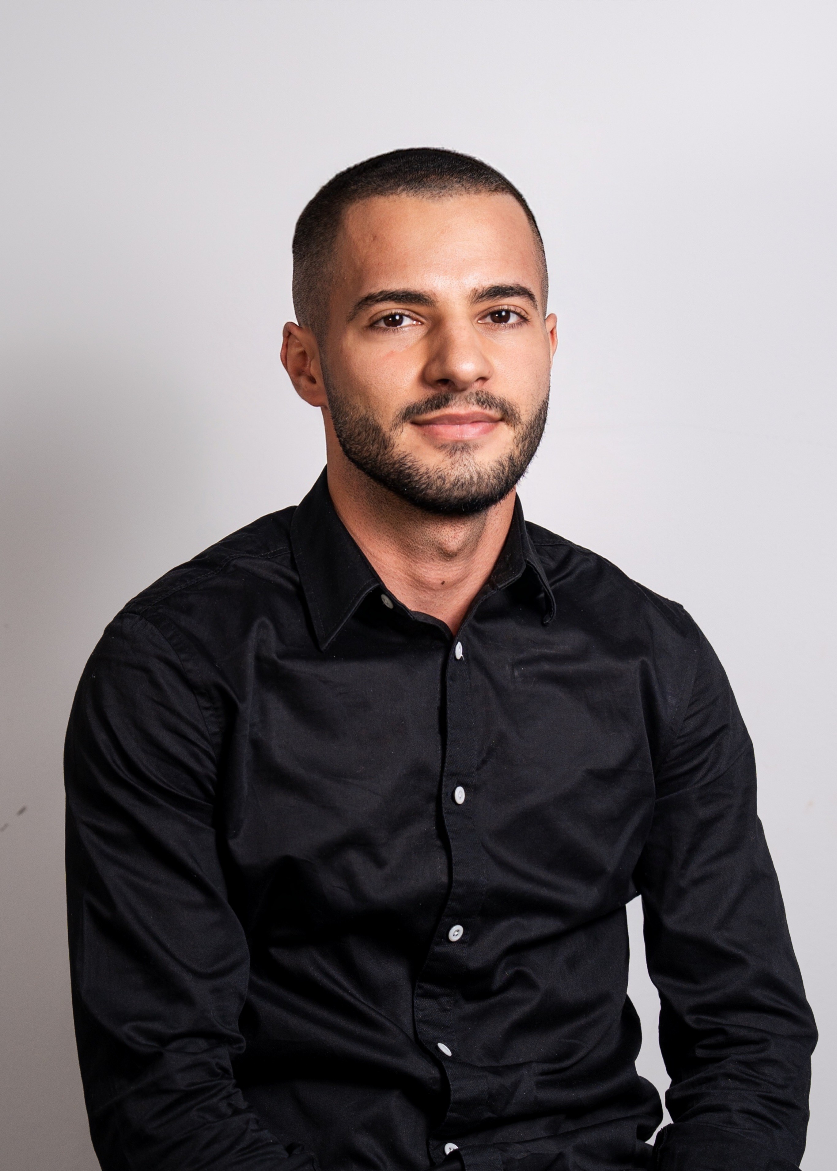 Portrait of a laughing person with curly hair wearing a white shirt