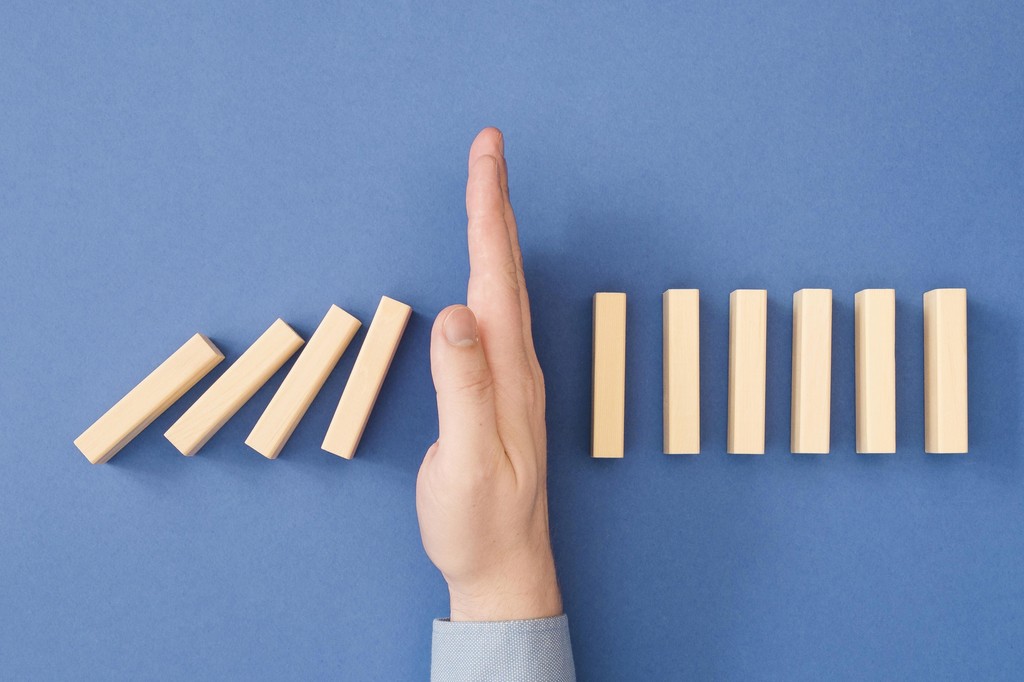 a hand saving blocks from falling