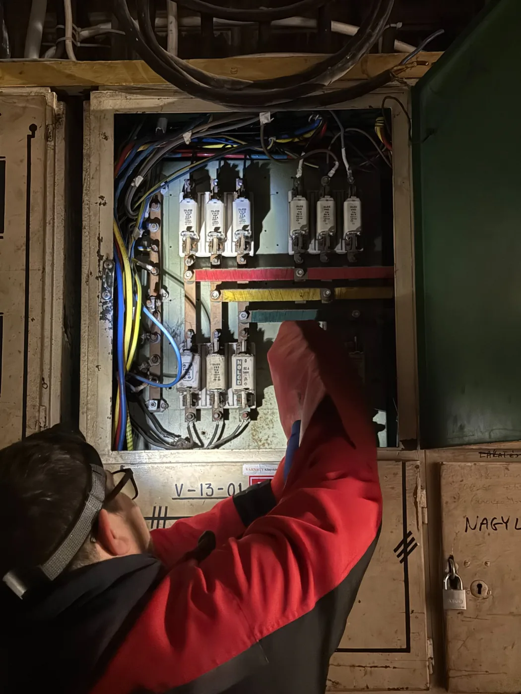 Ampermax szakember ipari biztosítékokat cserél egy nagyfeszültségű elosztószekrényben