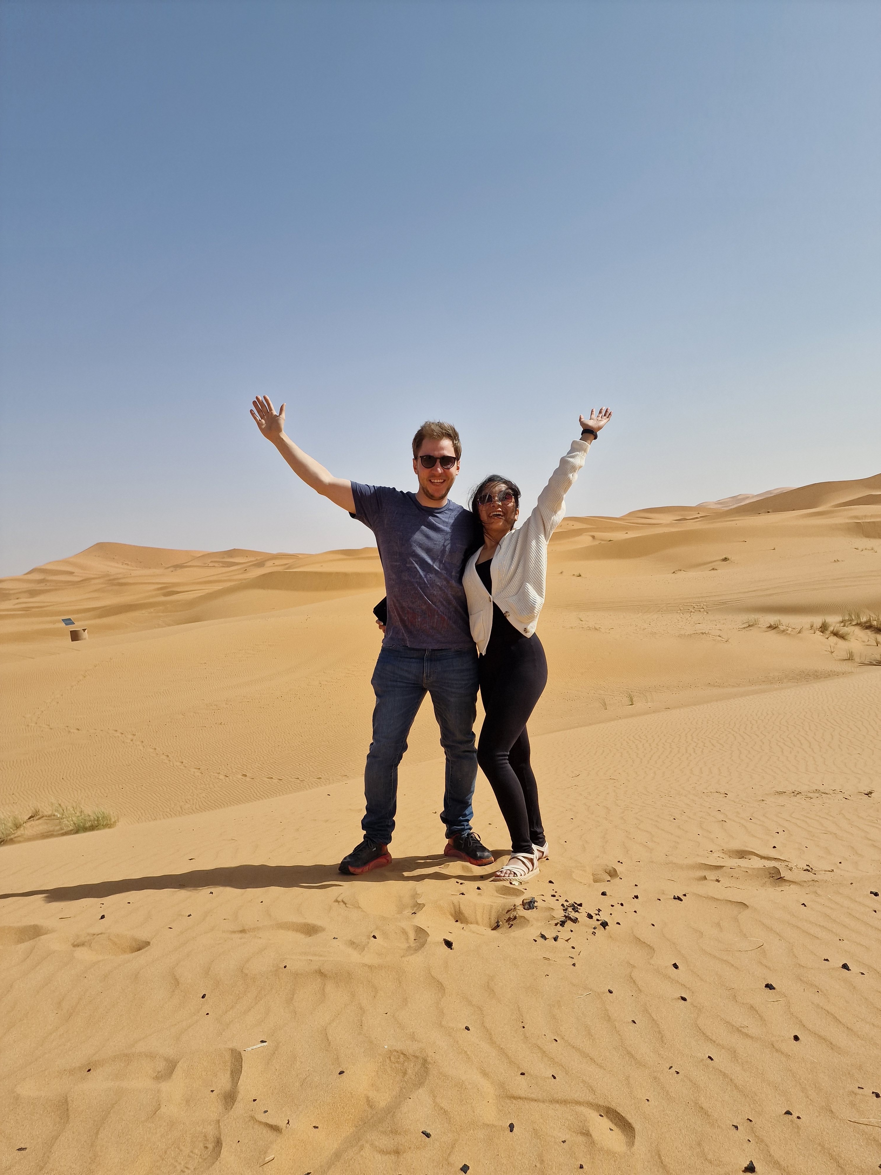 Close-up of two hands gently clasped, one wearing a sparkling engagement ring. The soft lighting and pastel nails evoke a sense of romance and intimacy.