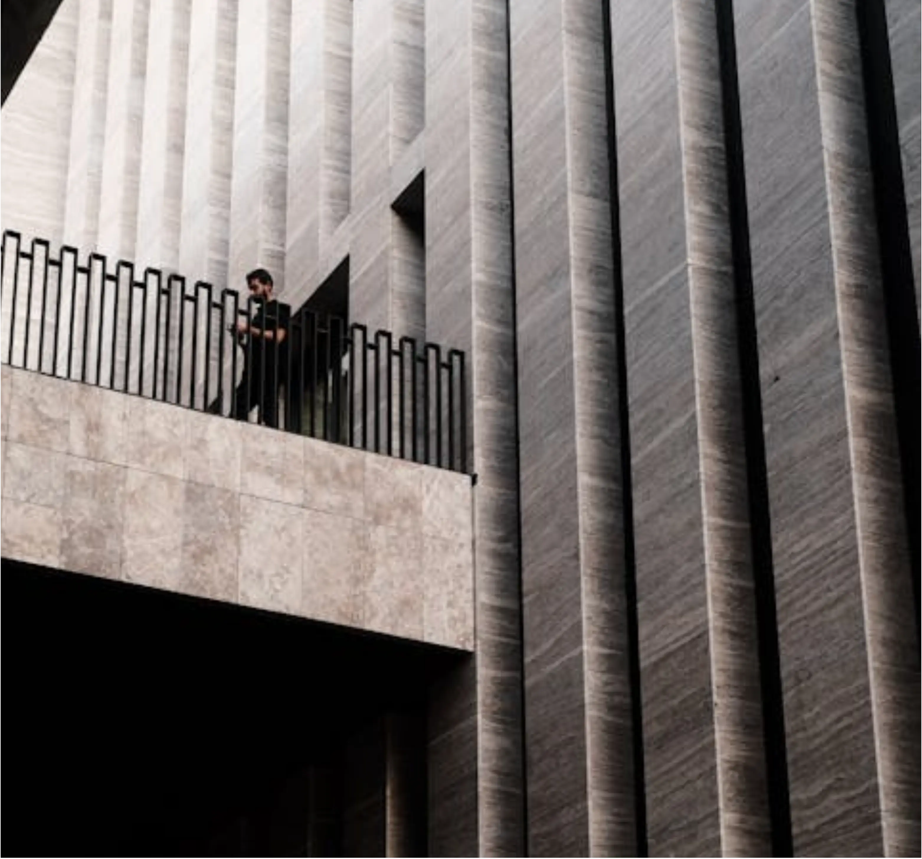 Eine Person auf einem Balkon eines großen Gebäudes